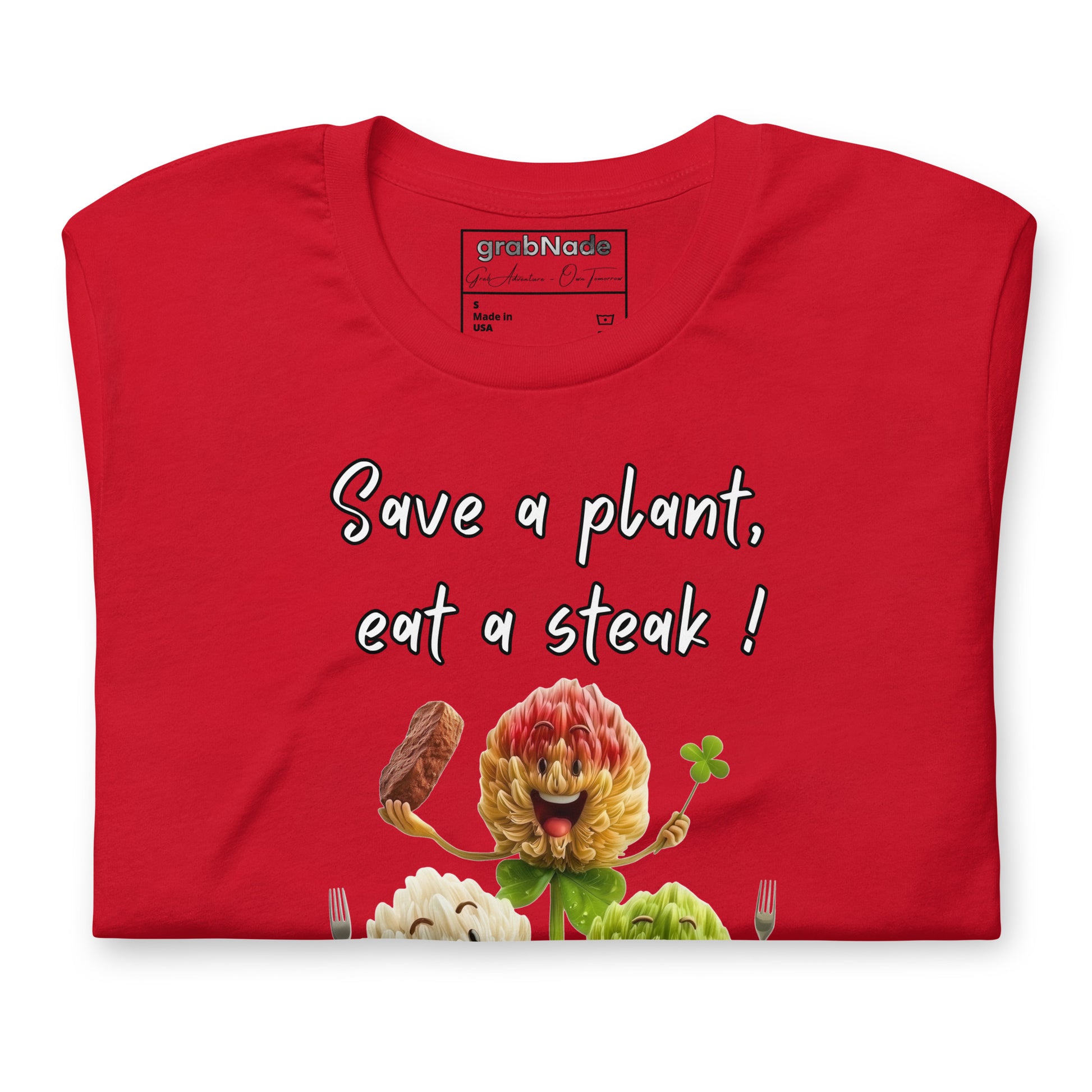 Product mockup. Red T-shirt folded to display "Save a plant, eat a steak!" and flower-shaped clover/steak graphics with carnivore club badge.