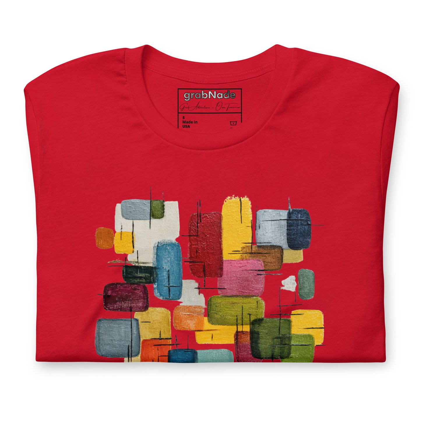 Product mockup. Red t-shirt, neatly folded, showing a colorful abstract geometric block design on the chest.