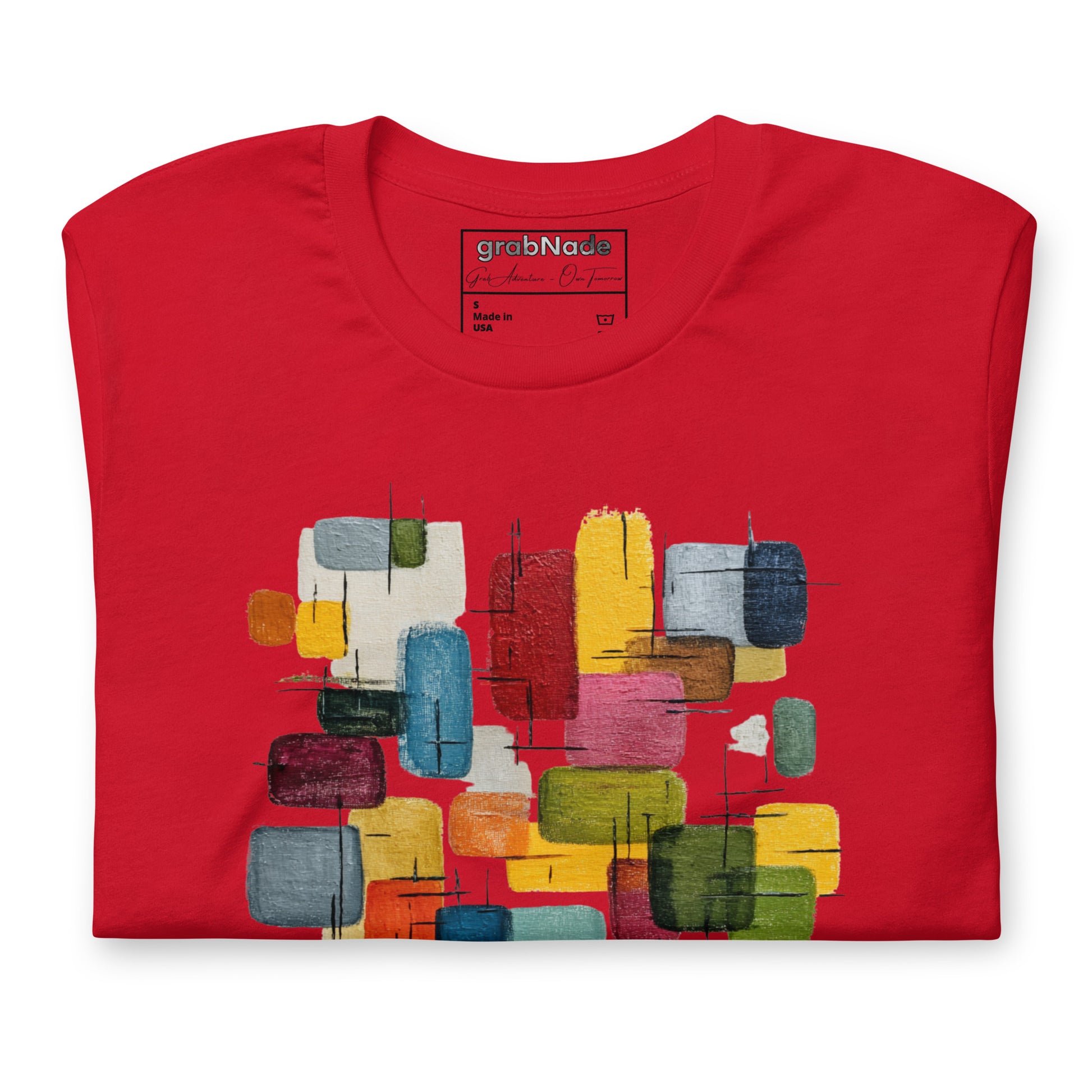 Product mockup. Red t-shirt, neatly folded, showing a colorful abstract geometric block design on the chest.