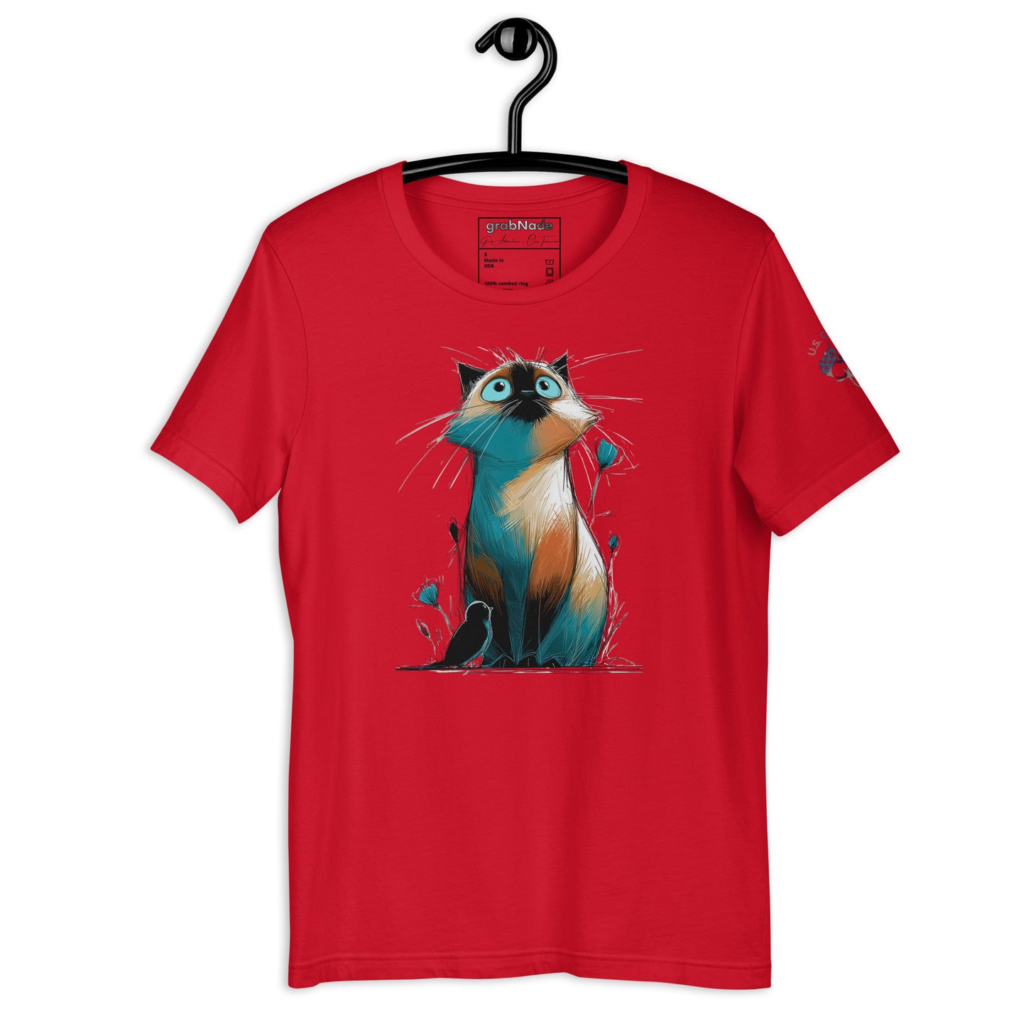 Product mockup. Red T-shirt on hanger, showing stylized cartoon cat with tall ears and wide eyes, sitting with whimsical grass and flowers.