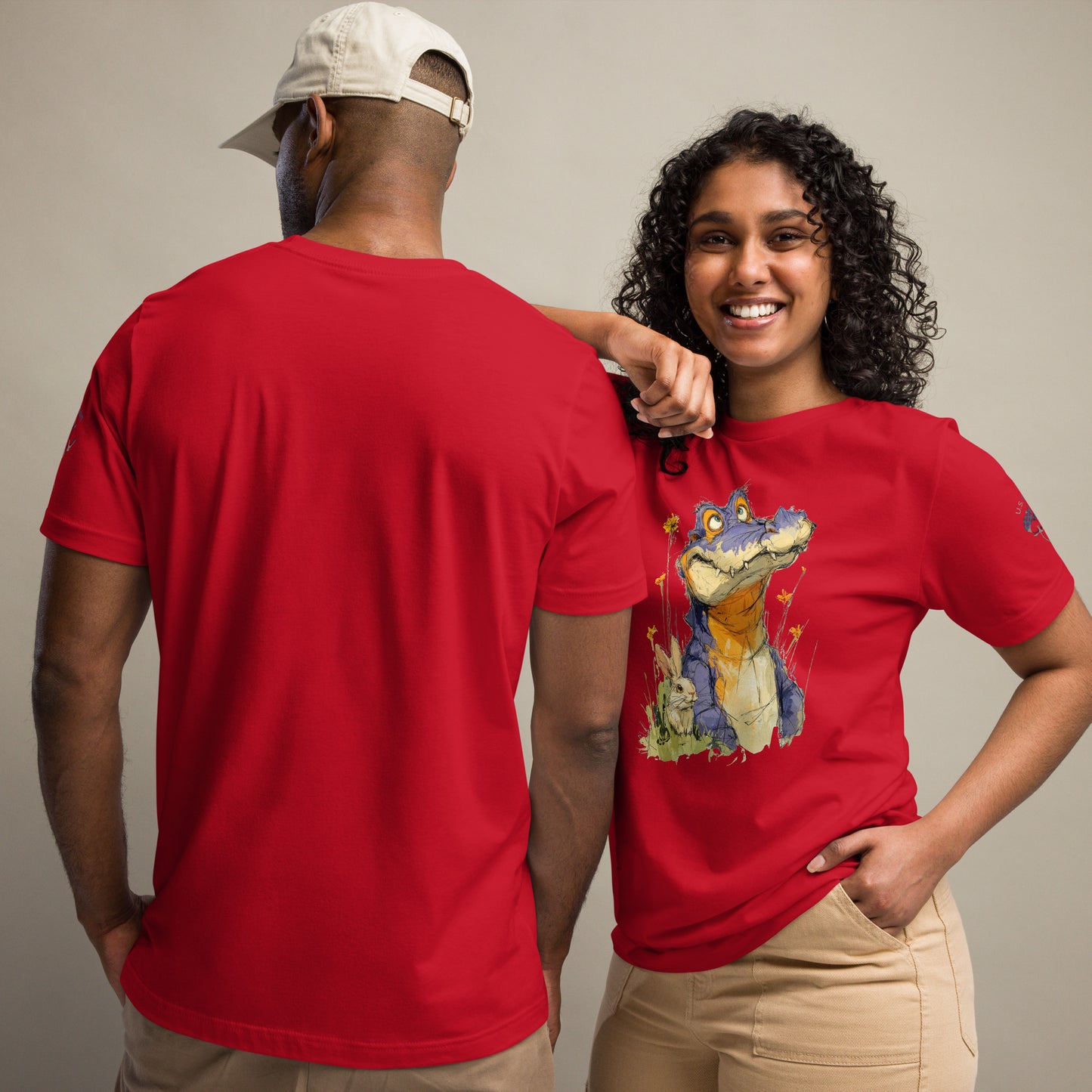 Product mockup. Man showing back of plain red T-shirt; woman in whimsical crocodile T-shirt with wildflowers.