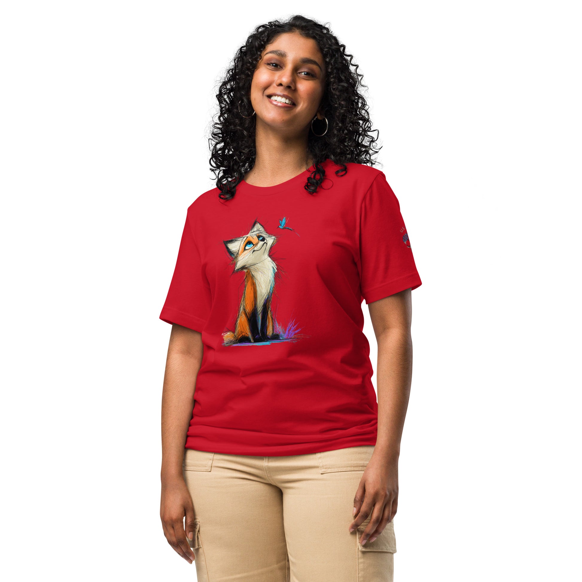 Product mockup. Woman in red T-shirt with cheerful, hand-drawn fox seated on grass, glancing up at a blue butterfly.