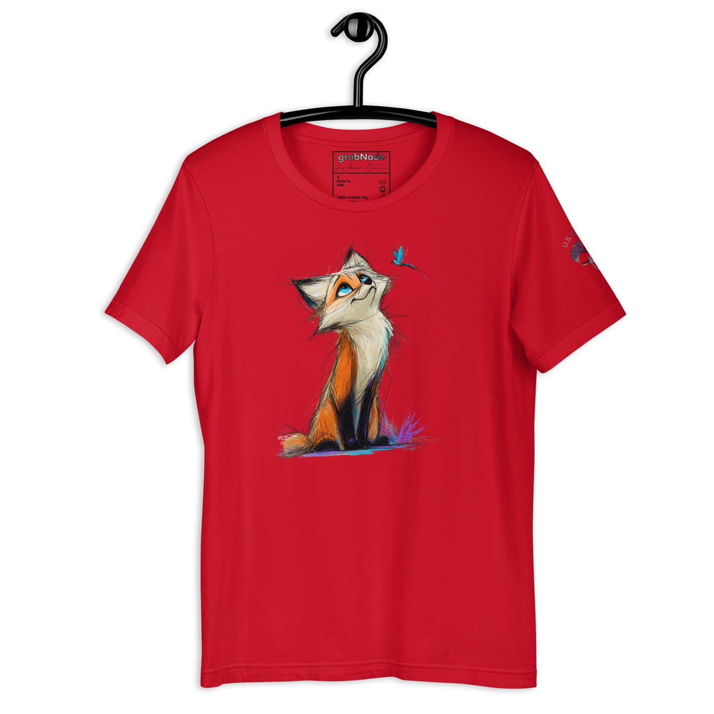 Product mockup. Red T-shirt on hanger featuring a stylized orange fox illustration with a blue bird, sitting in purple grass.