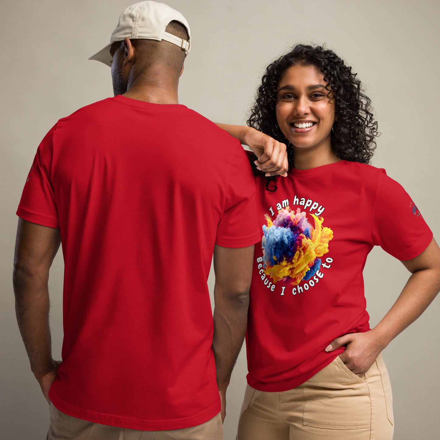 Product mockup. A man and woman stand together; the woman wears a red t-shirt with colorful text "I am happy because I choose to" around a bright swirling abstract cloud, while the man shows the back of a plain red t-shirt.