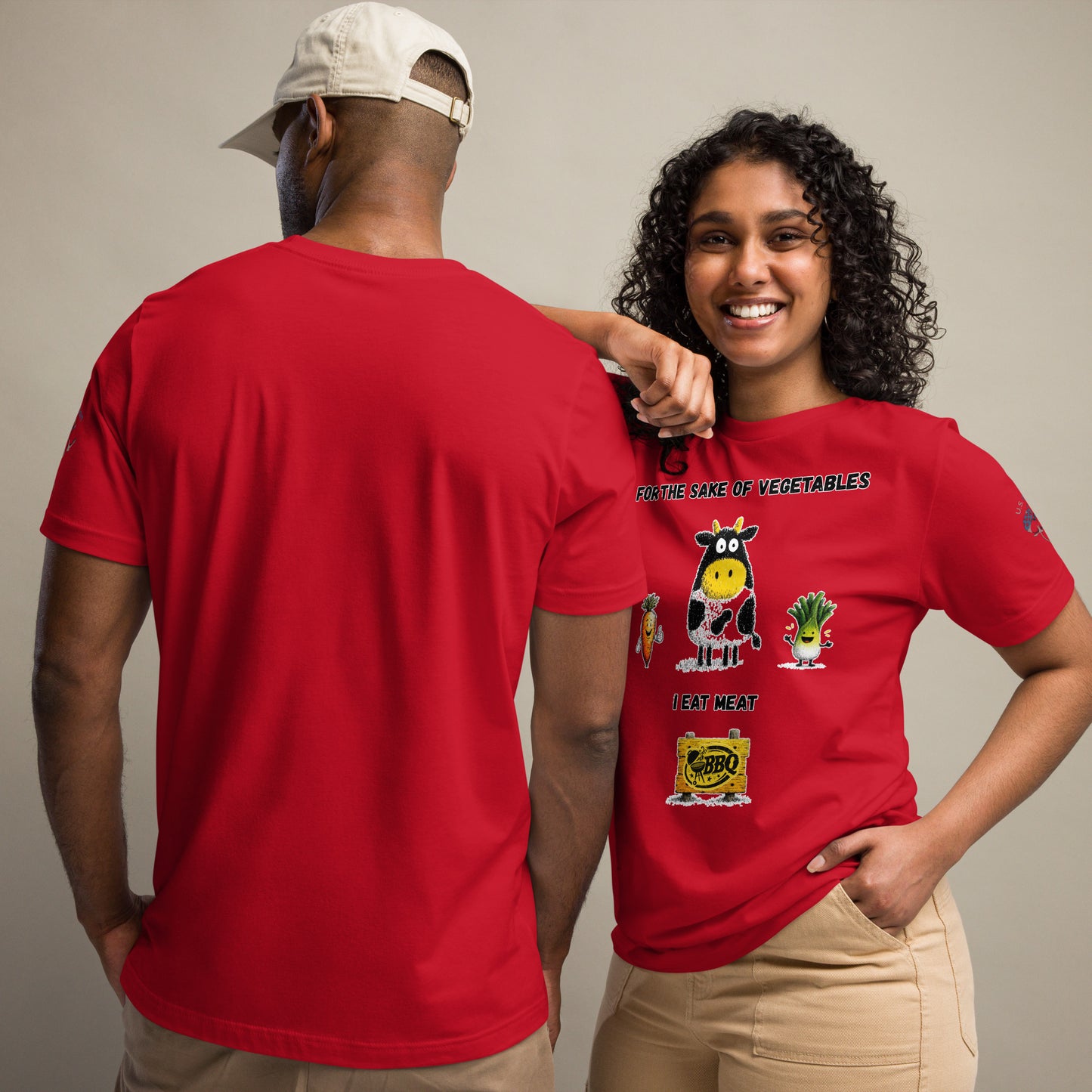 Product mockup. Man and woman in cargo pants, with the woman wearing a red T-shirt printed with a cartoon cow and veggies, text: “For the sake of vegetables I eat meat.”