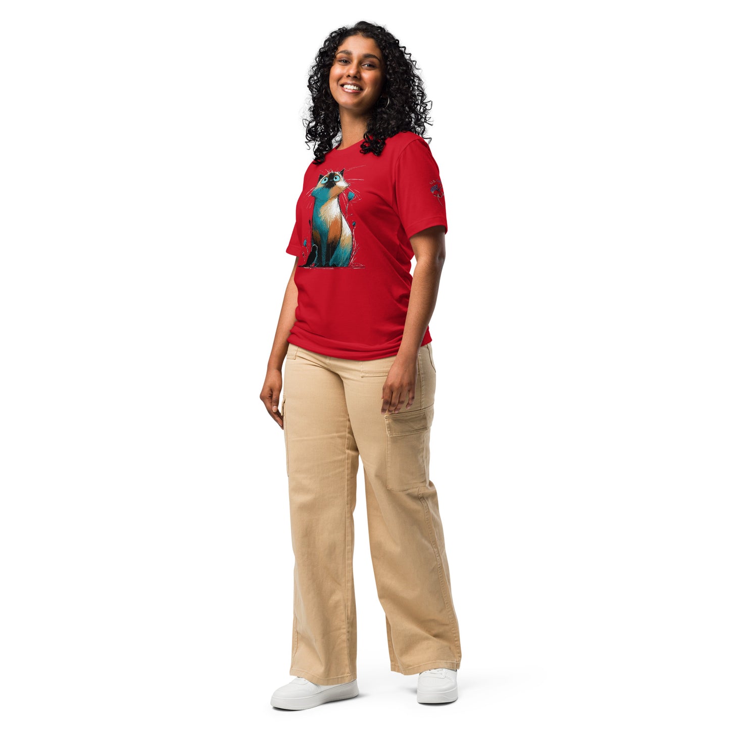 Product mockup.A woman standing in beige pants and a red T-shirt decorated with a large, colorful cartoon cat, shown in a full body pose.