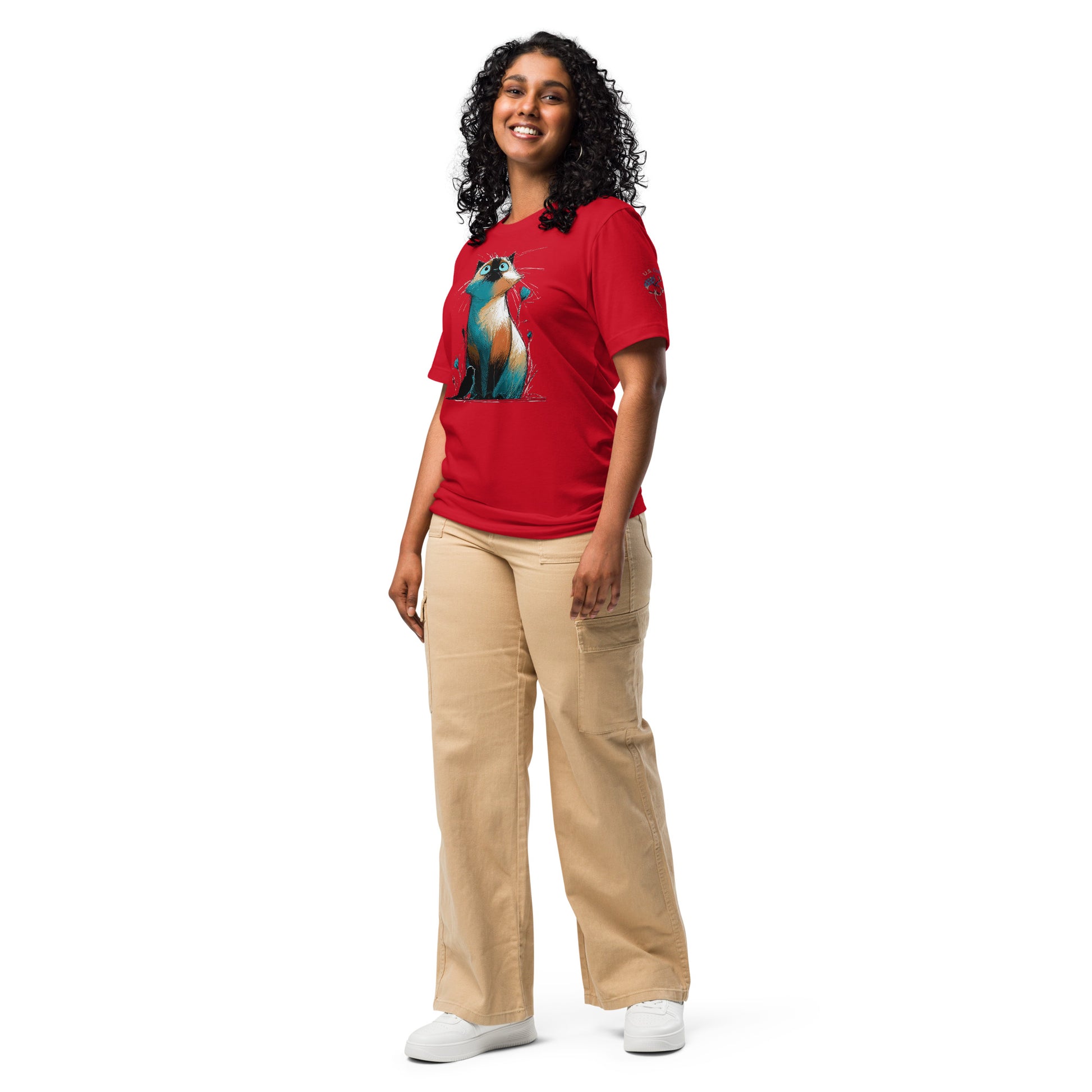 Product mockup.A woman standing in beige pants and a red T-shirt decorated with a large, colorful cartoon cat, shown in a full body pose.