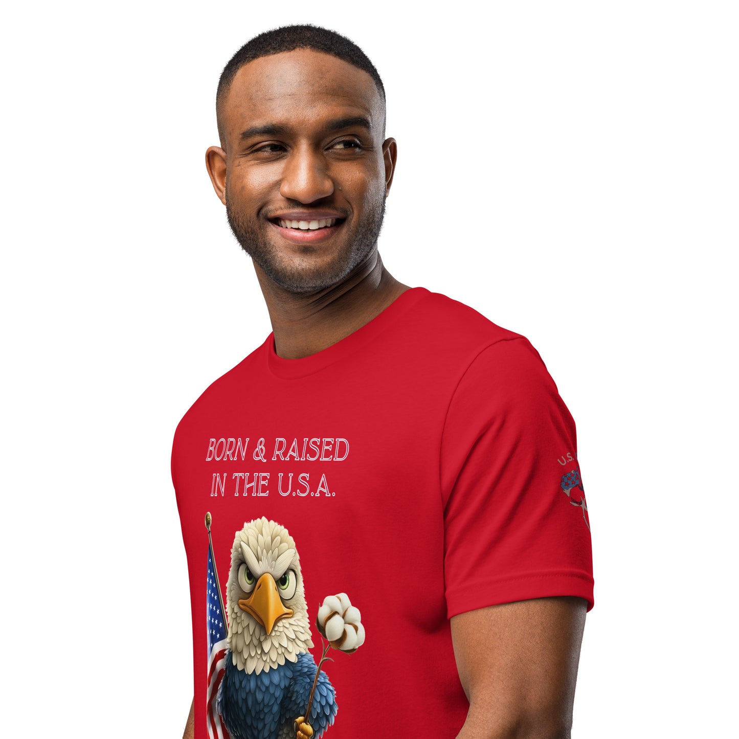 Product mockup. Premium red cotton t-shirt worn by a man; close-up left angle shows large “Born & Raised in the U.S.A.” eagle graphic, American flag, and cotton flower. Classic fit.