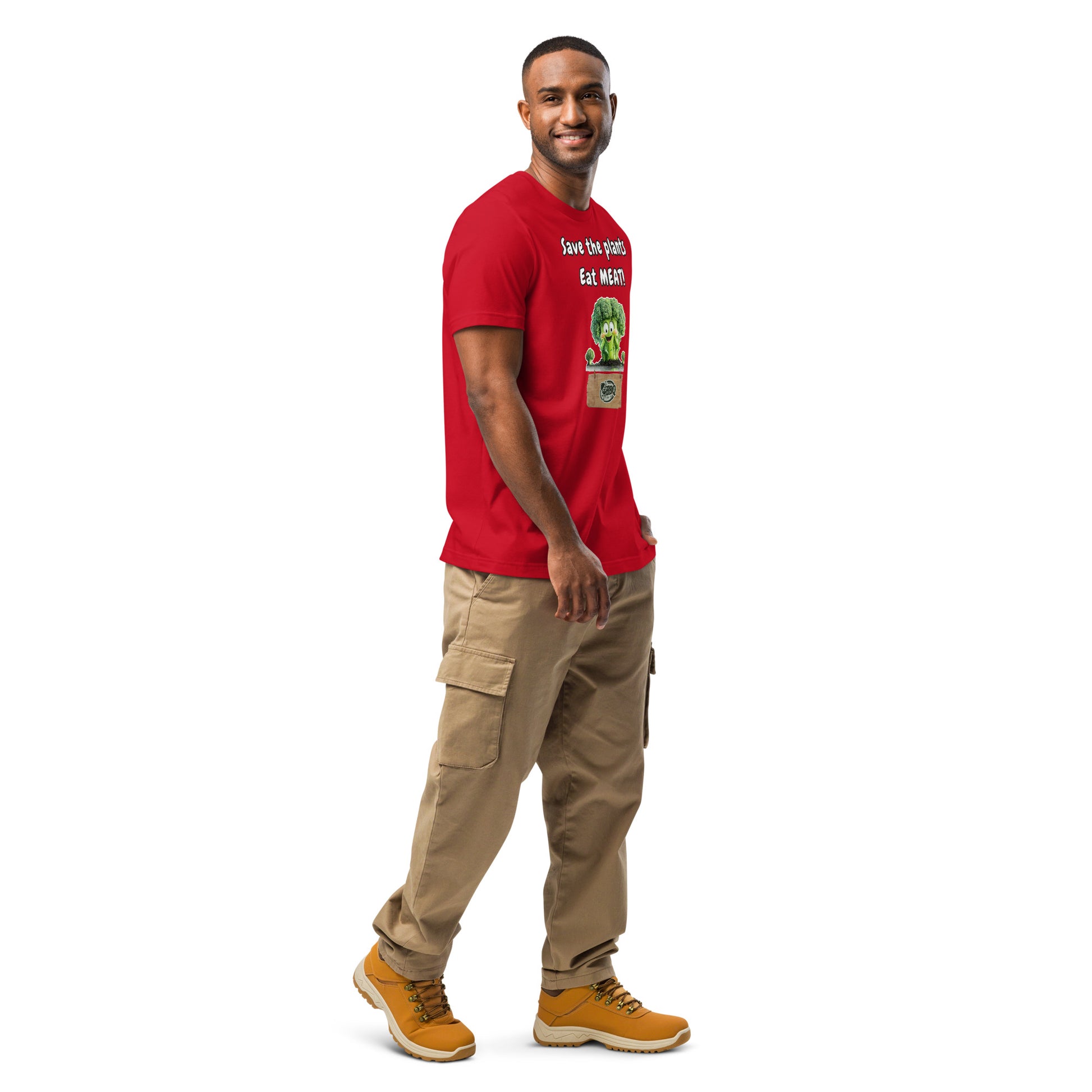 Product mockup.A man standing in tan cargo pants and boots, modeling a red T-shirt with a big cartoon broccoli and the slogan “Save the plants, Eat MEAT!”, full body.