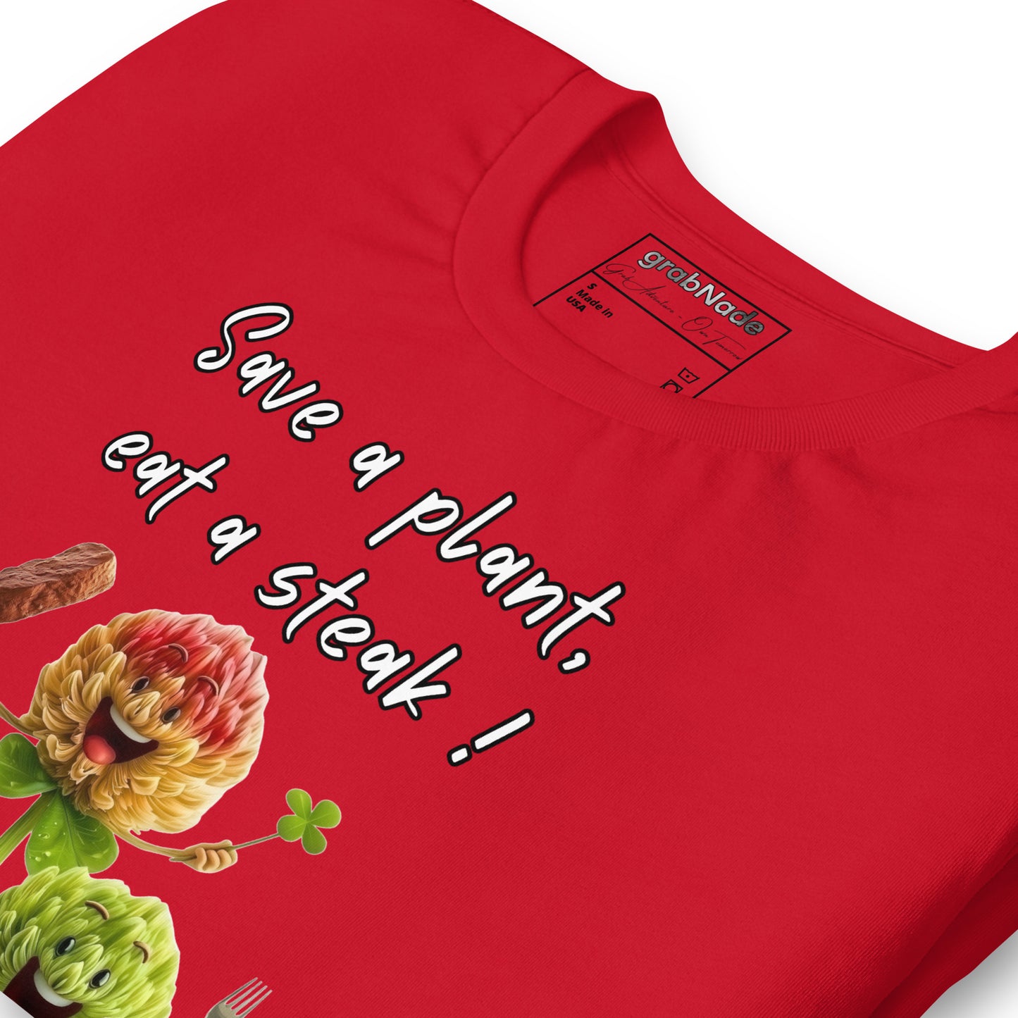 Product mockup. Close-up view of a red T-shirt featuring smiling cartoon flower characters, a steak, and the playful text “Save a plant, eat a steak!”.