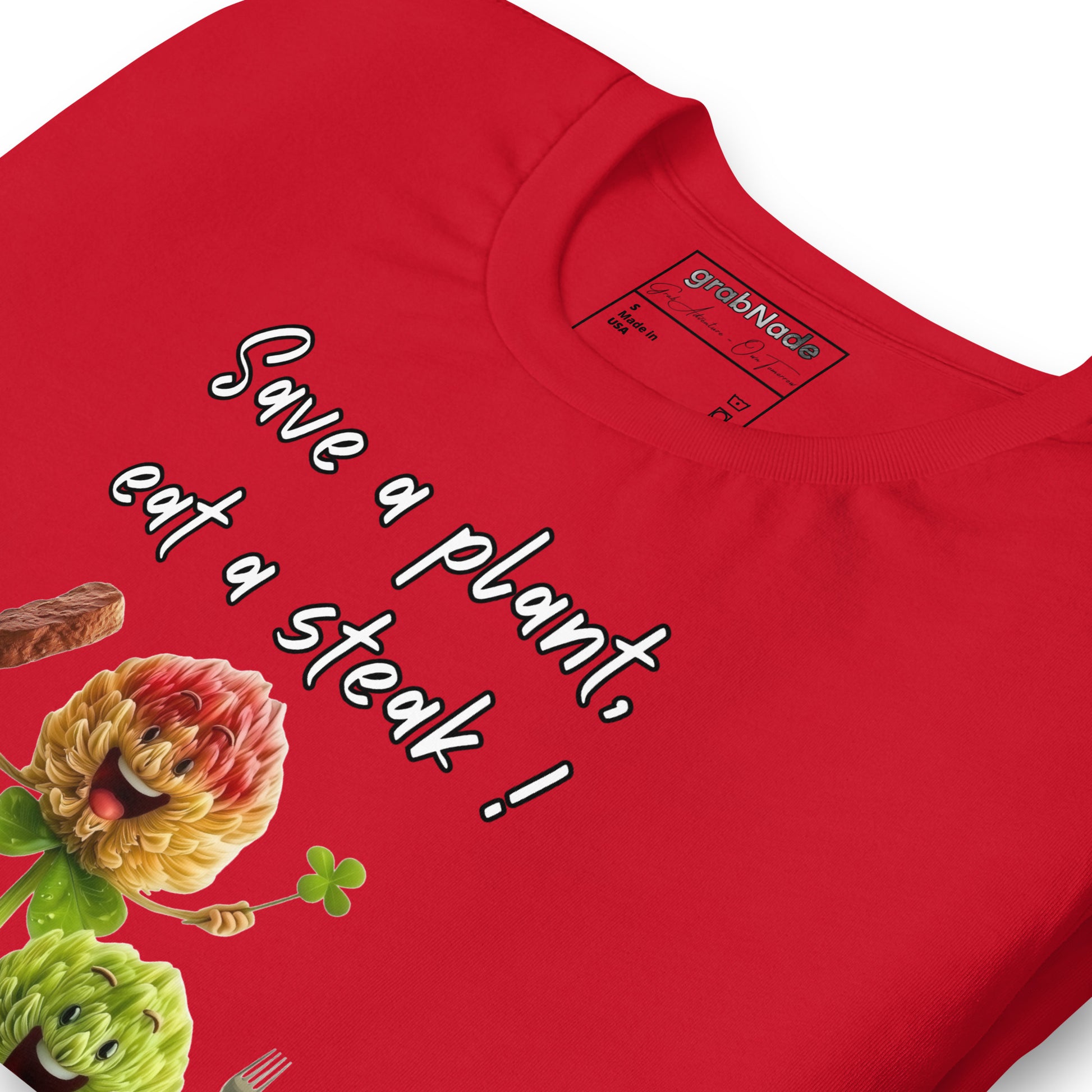 Product mockup. Close-up view of a red T-shirt featuring smiling cartoon flower characters, a steak, and the playful text “Save a plant, eat a steak!”.