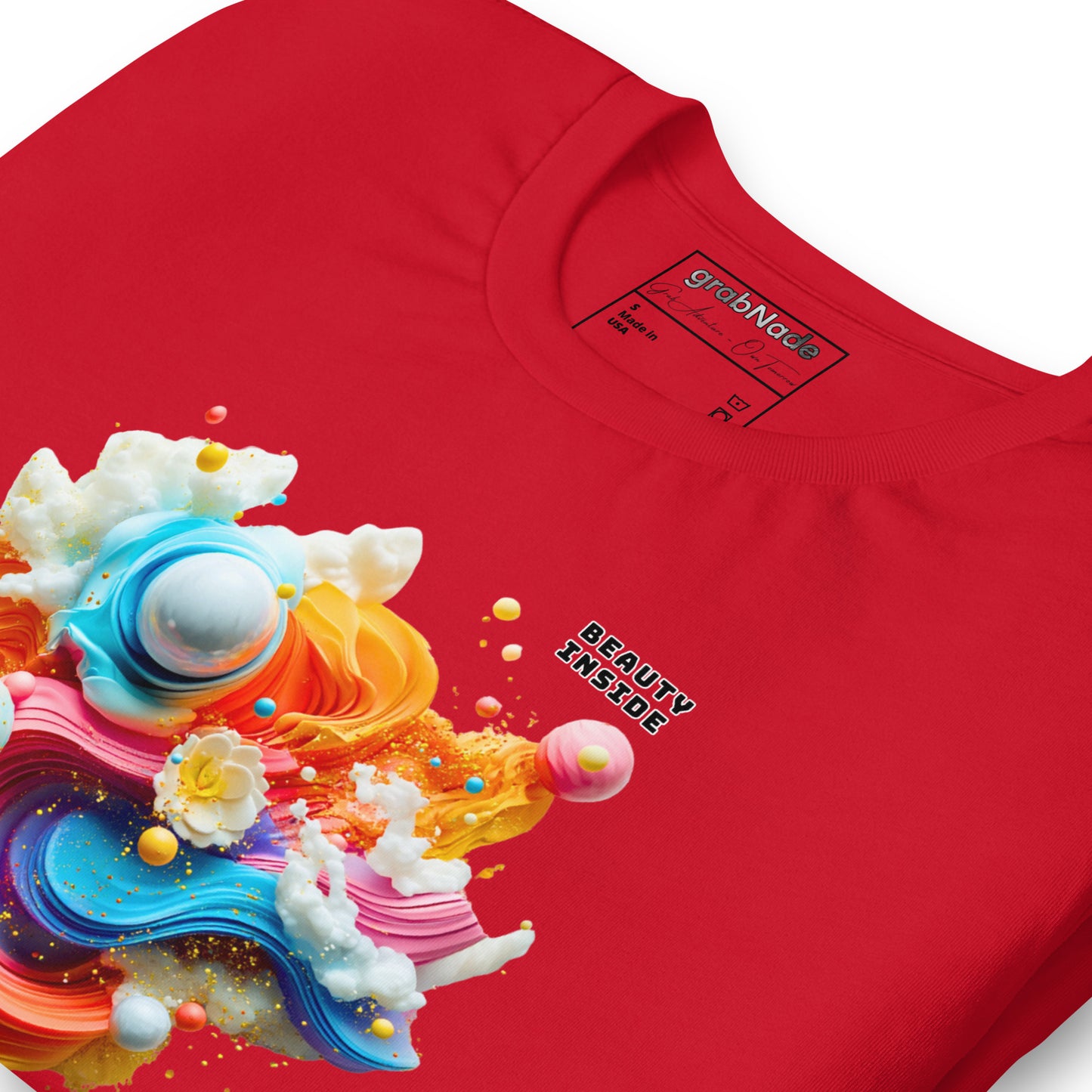 Product mockup. Close-up view of a red T-shirt with a large, colorful 3D swirl of abstract shapes, spheres, and clouds and the text “BEAUTY INSIDE”.
