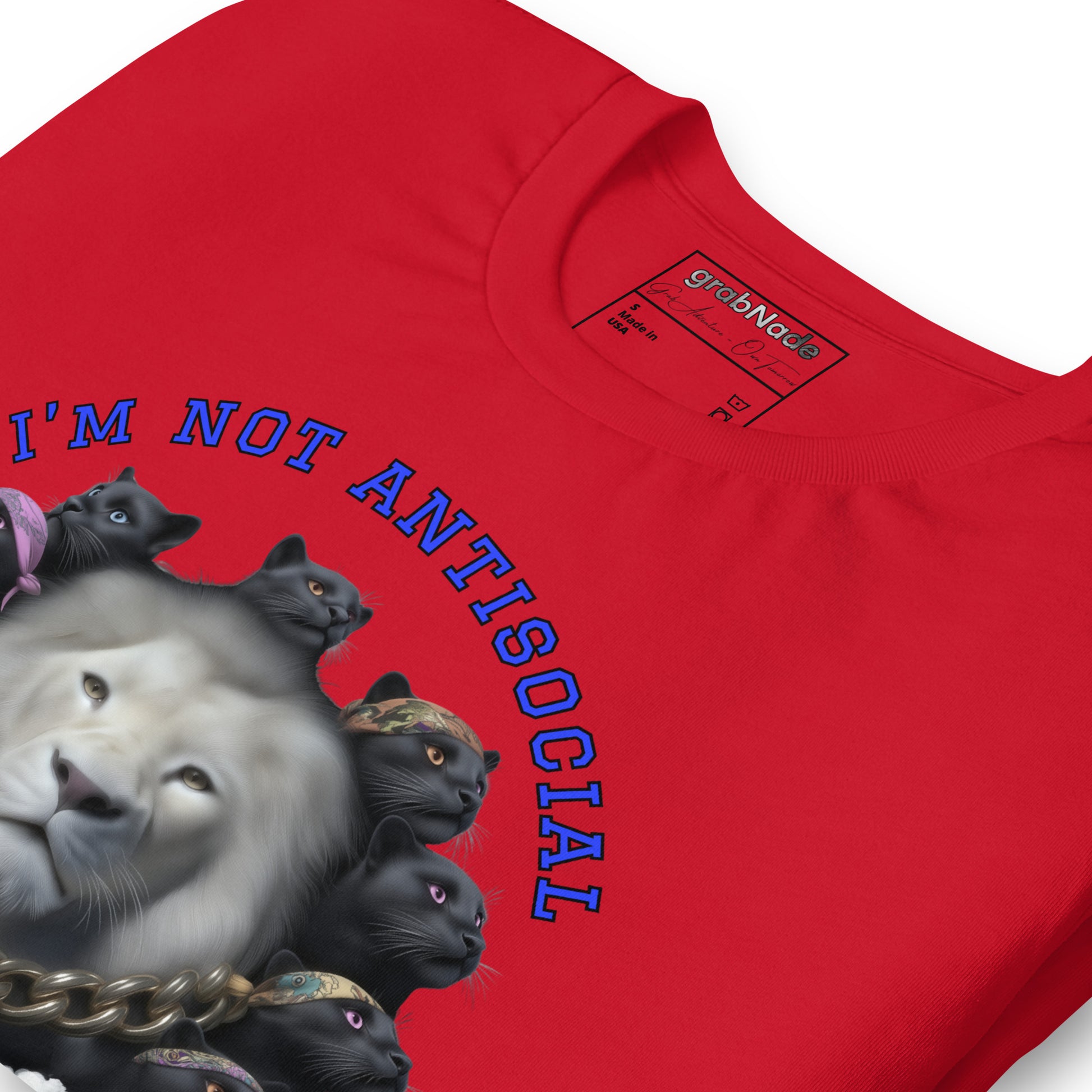 Product mockup. Close-up of a red T-shirt showing a realistic white lion and a group of black cats wearing bandanas, above the phrase “I’M NOT ANTISOCIAL”.