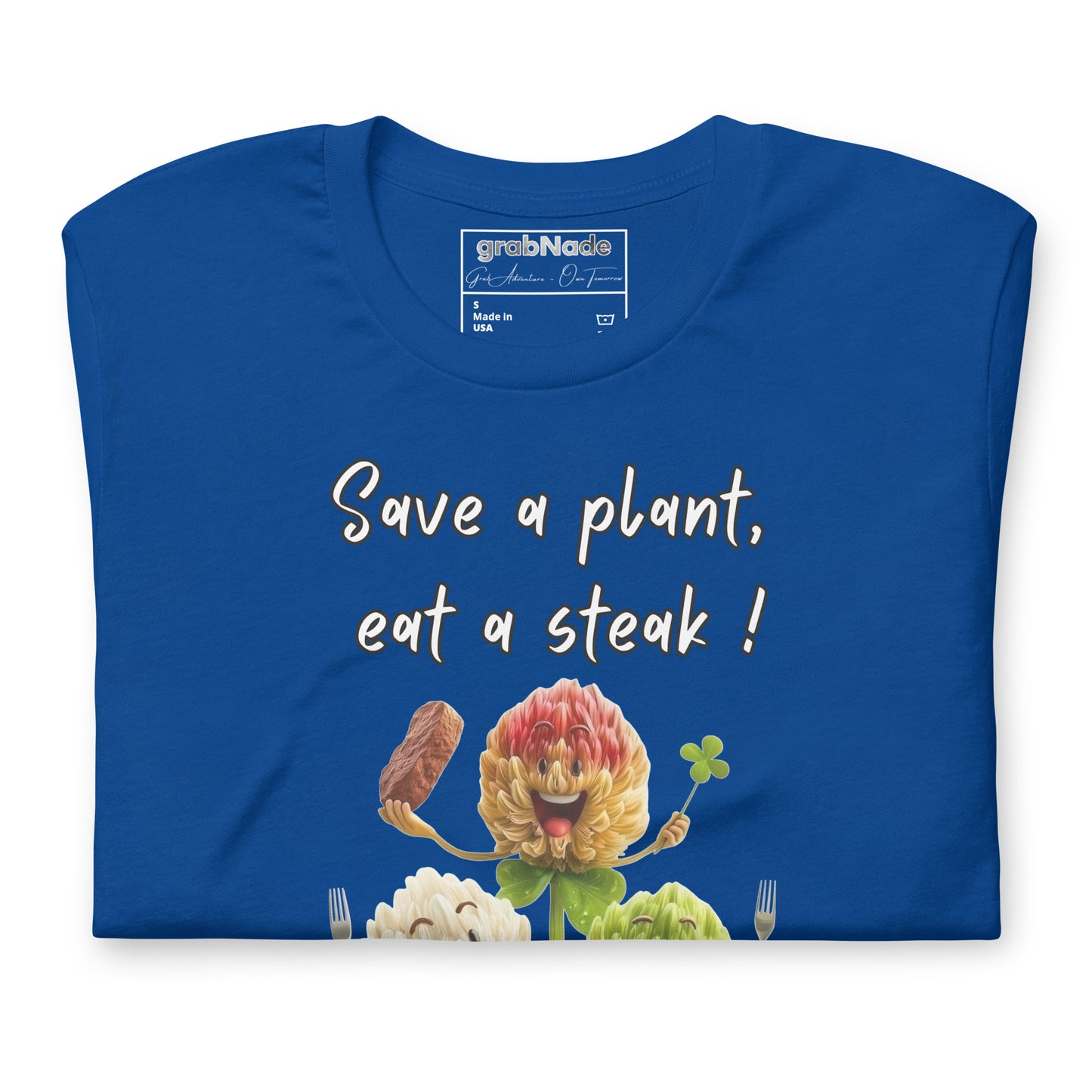 Product mockup. Close-up of a folded royal blue T-shirt with three cheerful cartoon flowers, a steak, and the phrase “Save a plant, eat a steak!” above them.