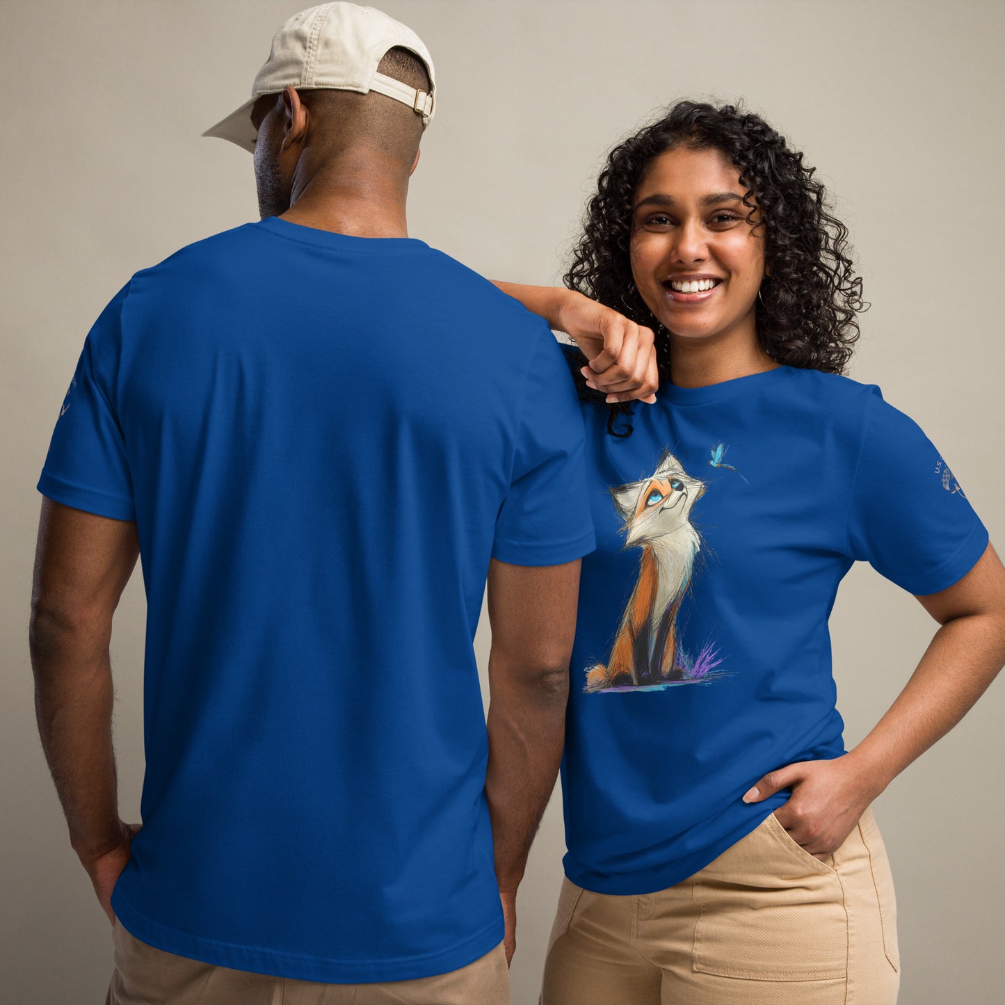 Product mockup. Man and woman in blue t-shirts; woman in beige pants, both with a hand-drawn fox looking up at a butterfly on the shirt, man with back view.