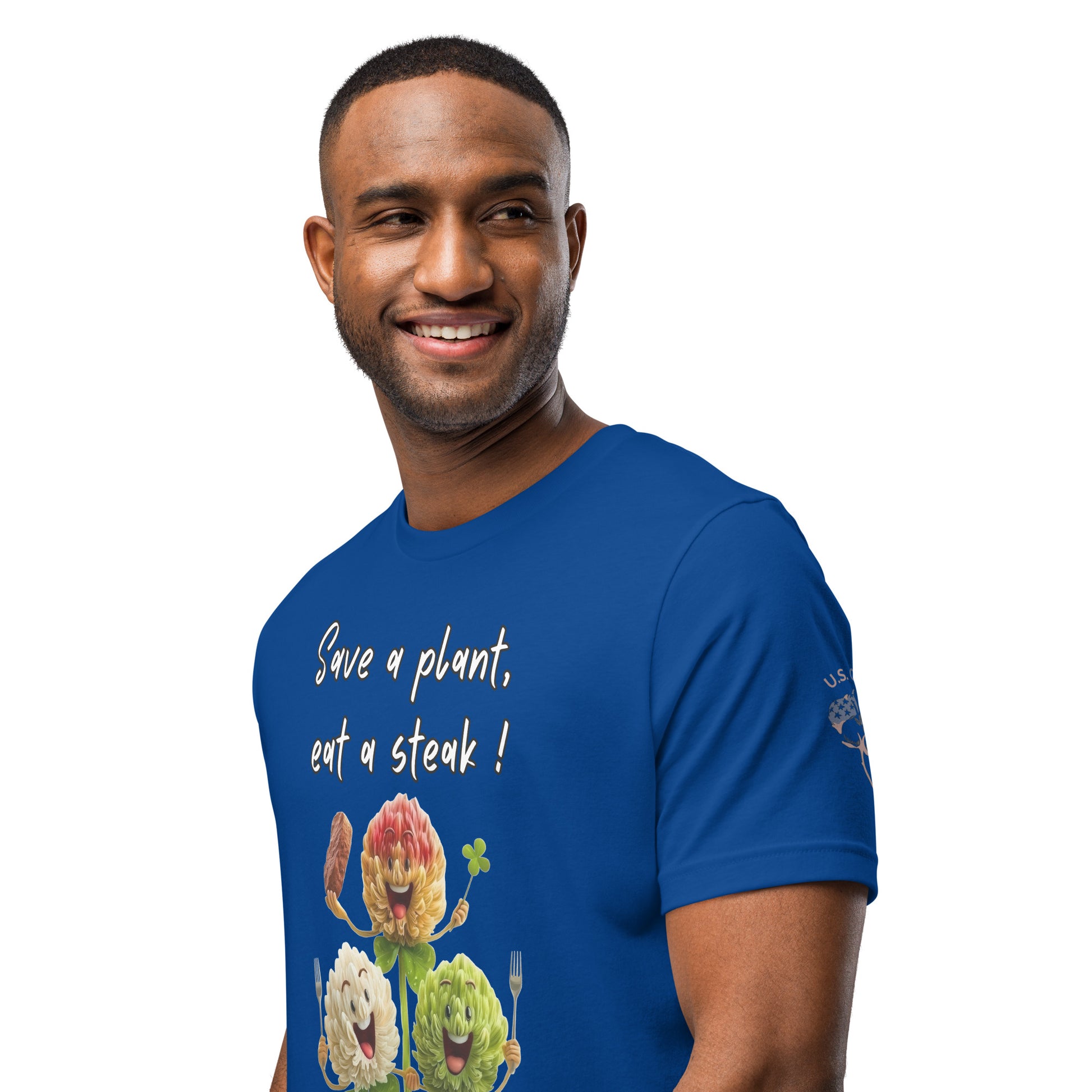 Product mockup. Blue T-shirt left front, “U.S. Cotton” and cotton boll on sleeve; chest features three cartoon vegetables and text “Save a plant, eat a steak!”, close-up from the torso up.