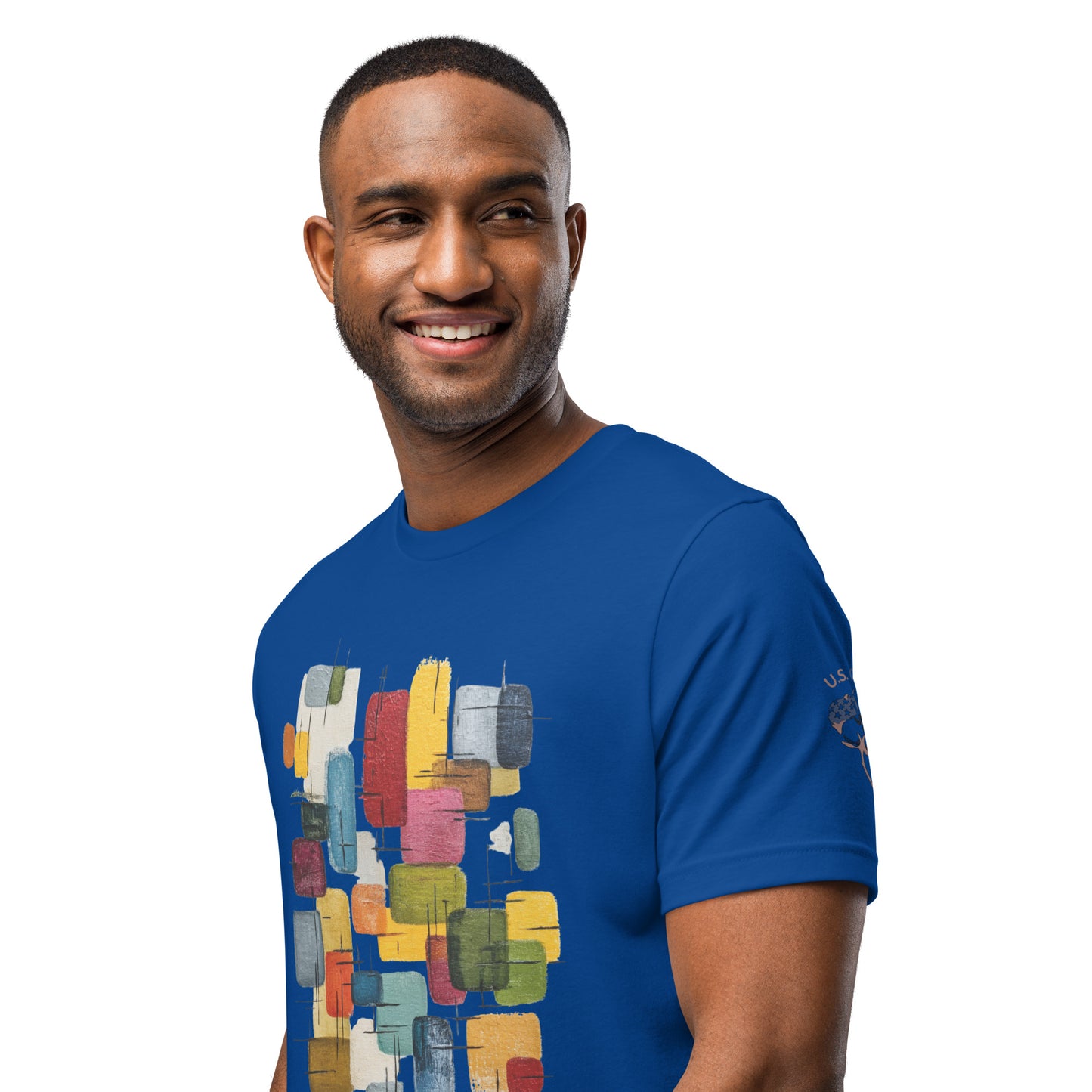 Product mockup. Left front view of blue T-shirt with sleeve showing a cotton boll and “U.S. Cotton”; chest has a rainbow geometric block design, close-up from the torso up.