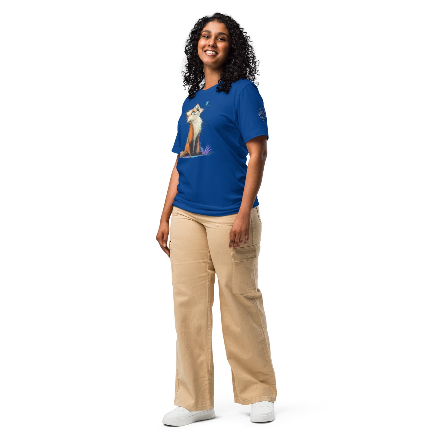 Product mockup. A woman wearing beige cargo pants and a bright blue T-shirt with a large, colorful cartoon fox and a small blue butterfly illustration on the front, shown in a full-body pose.