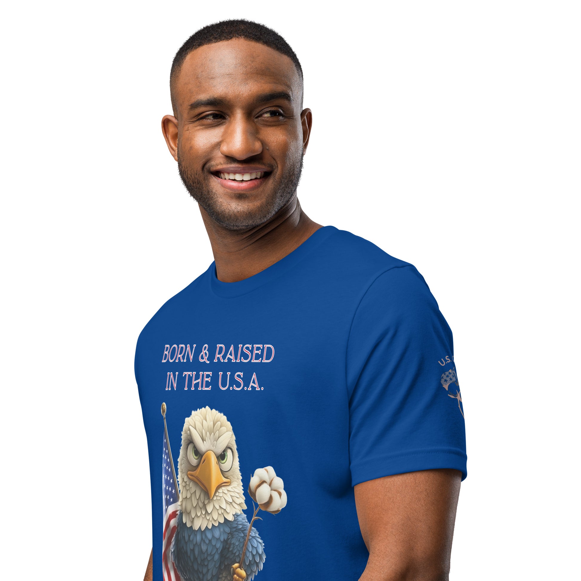 Product mockup. Smiling man wearing a blue T-shirt with a cartoon bald eagle holding a cotton flower and the American flag, and the text "BORN & RAISED IN THE U.S.A."