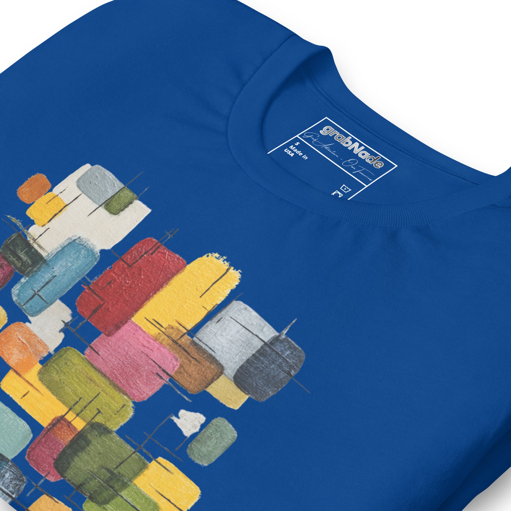 Product mockup. Blue T-shirt, zoomed in, showing abstract blocks in various colors (yellow, red, blue, green, pink).
