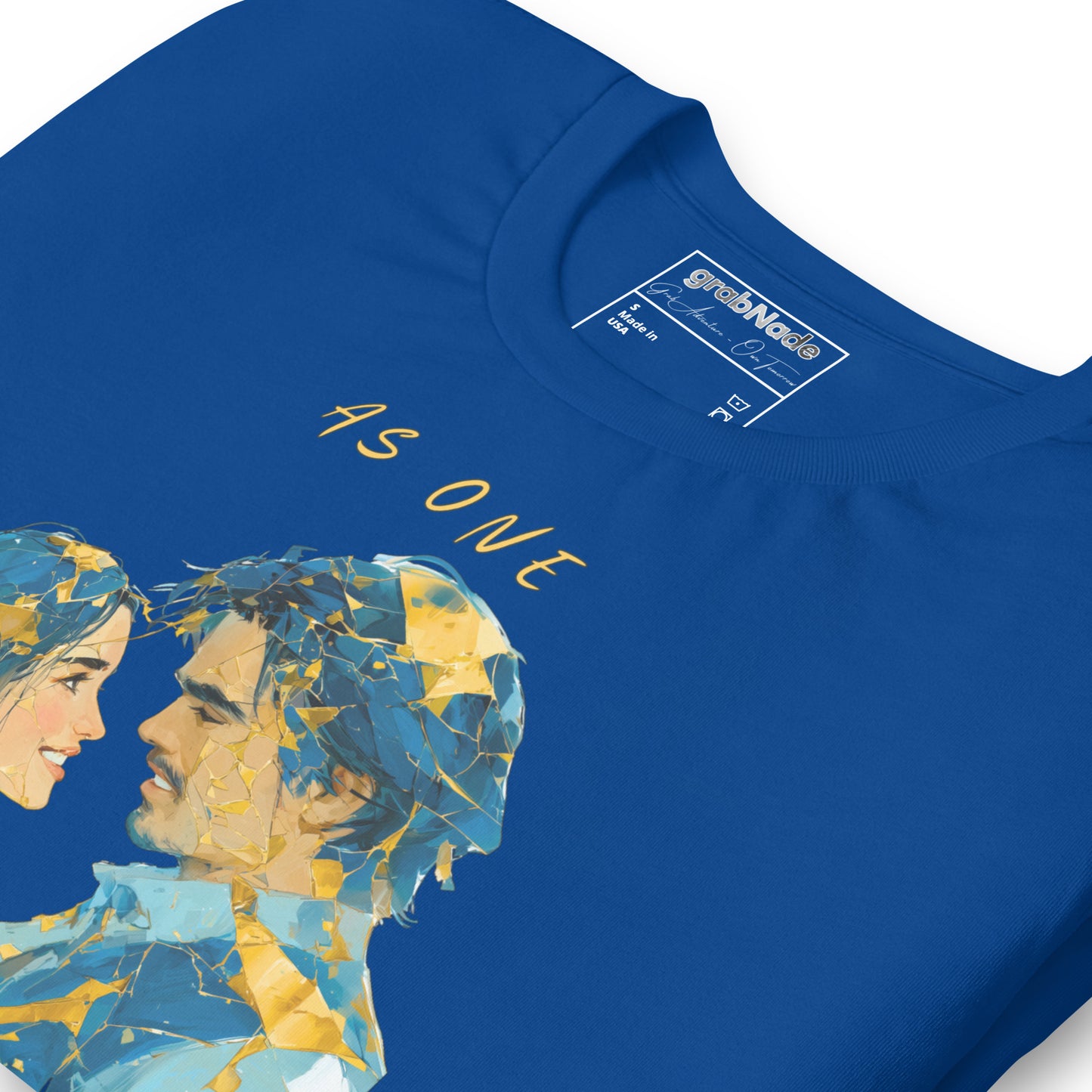 Product mockup. Blue T-shirt, zoomed in, two cracked sculpture heads facing; gold and blue mosaic, with “AS ONE.”
