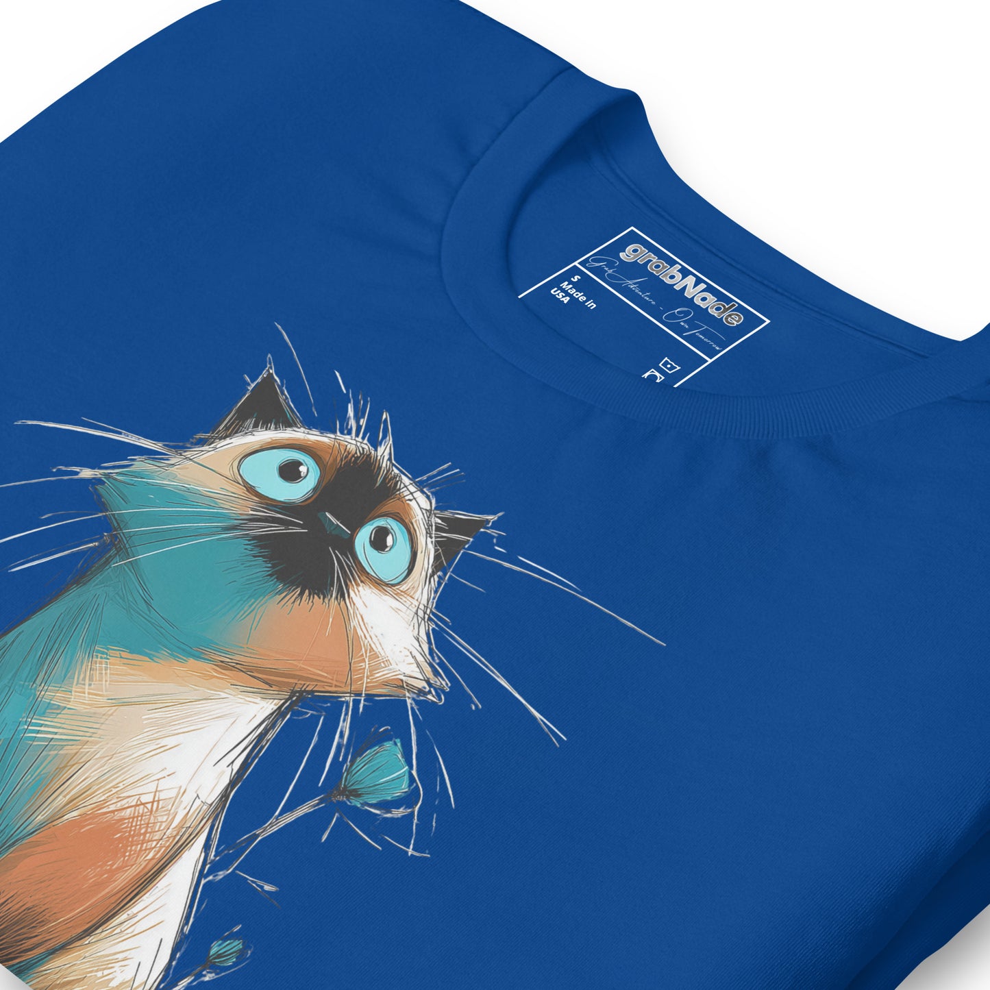 Product mockup. Blue T-shirt, zoomed in, sketch-style wide-eyed Siamese cat with blue eyes and whiskers, blue background.
