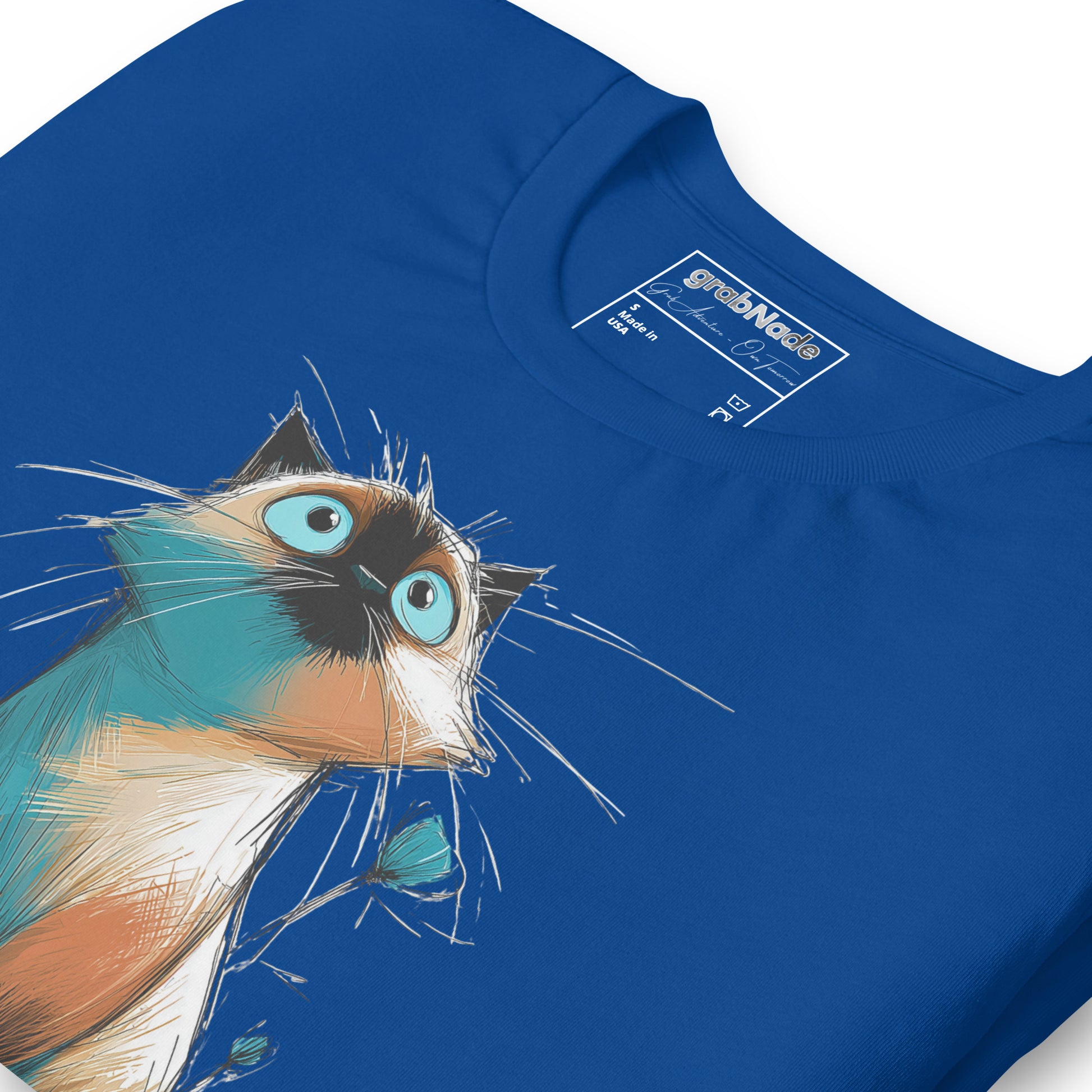 Product mockup. Blue T-shirt, zoomed in, sketch-style wide-eyed Siamese cat with blue eyes and whiskers, blue background.