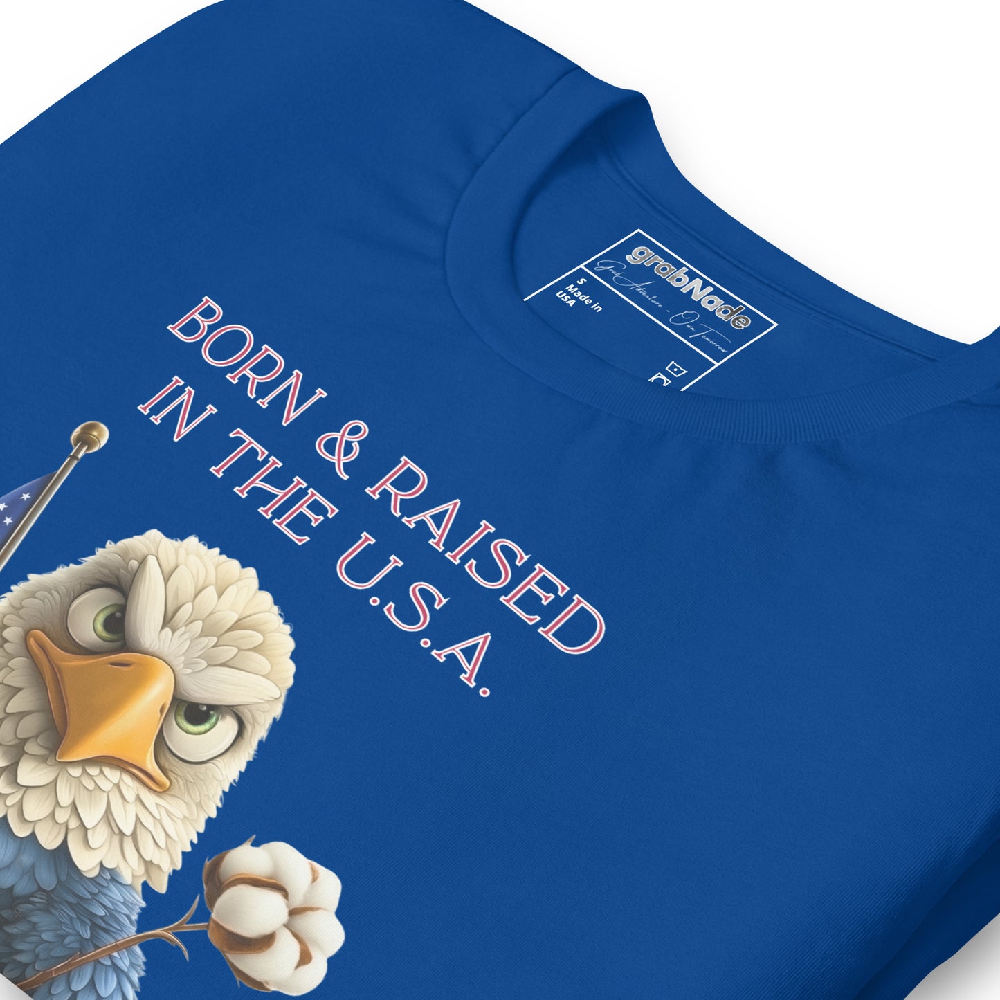 Product mockup. Blue T-shirt, zoomed in, stylized eagle with cotton bloom and US flag, text: “BORN & RAISED IN THE U.S.A.”