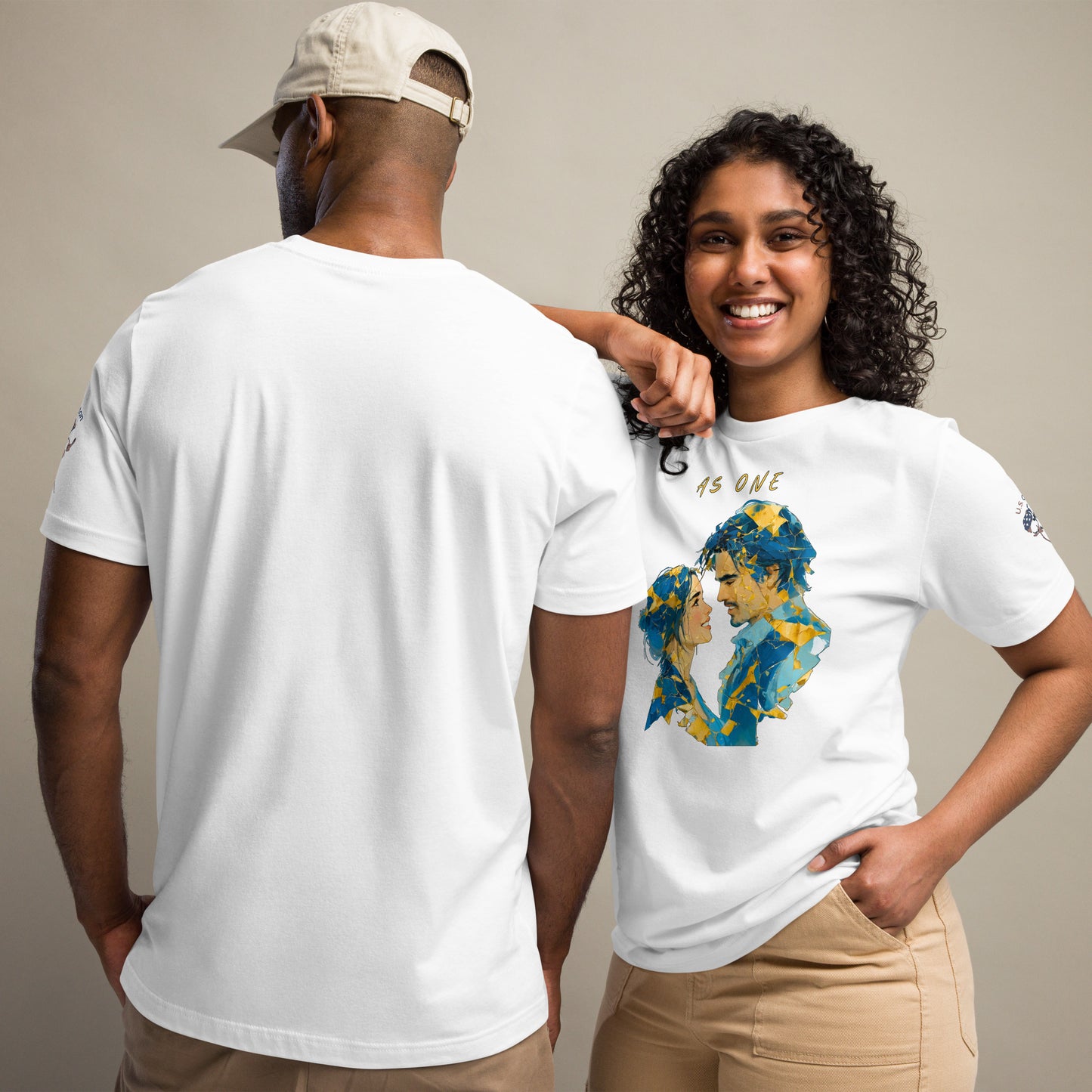 Product mockup. Man showing back of plain white T-shirt; woman in “As One” T-shirt with yellow and blue abstract earth design.