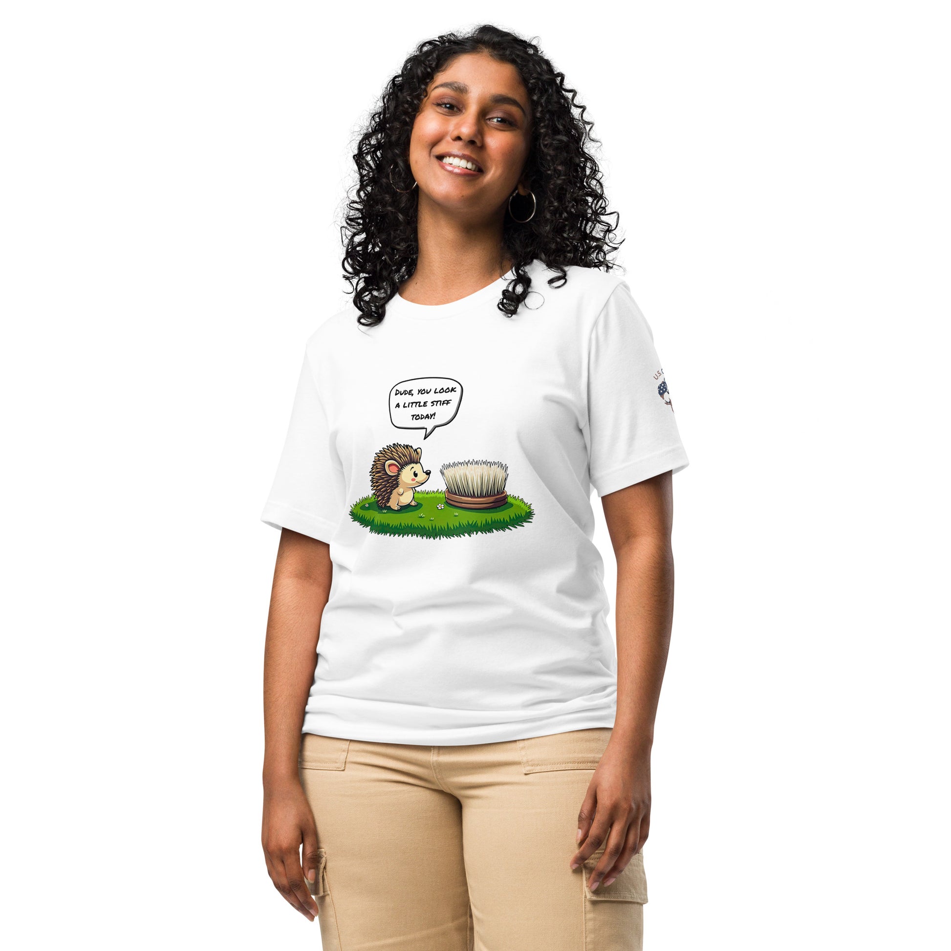 Product mockup. Woman wearing T-shirt with an illustrated hedgehog speaking to a hairbrush on grass, saying: "Dude, you look a little stiff today!"