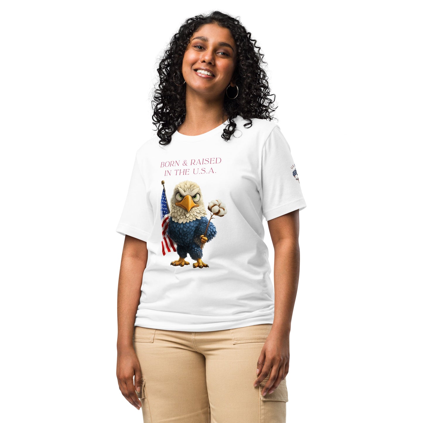 Product mockup. A woman stands wearing a white t-shirt with a cartoon bald eagle holding a cotton flower and standing by an American flag, above the phrase "Born & Raised in the U.S.A."