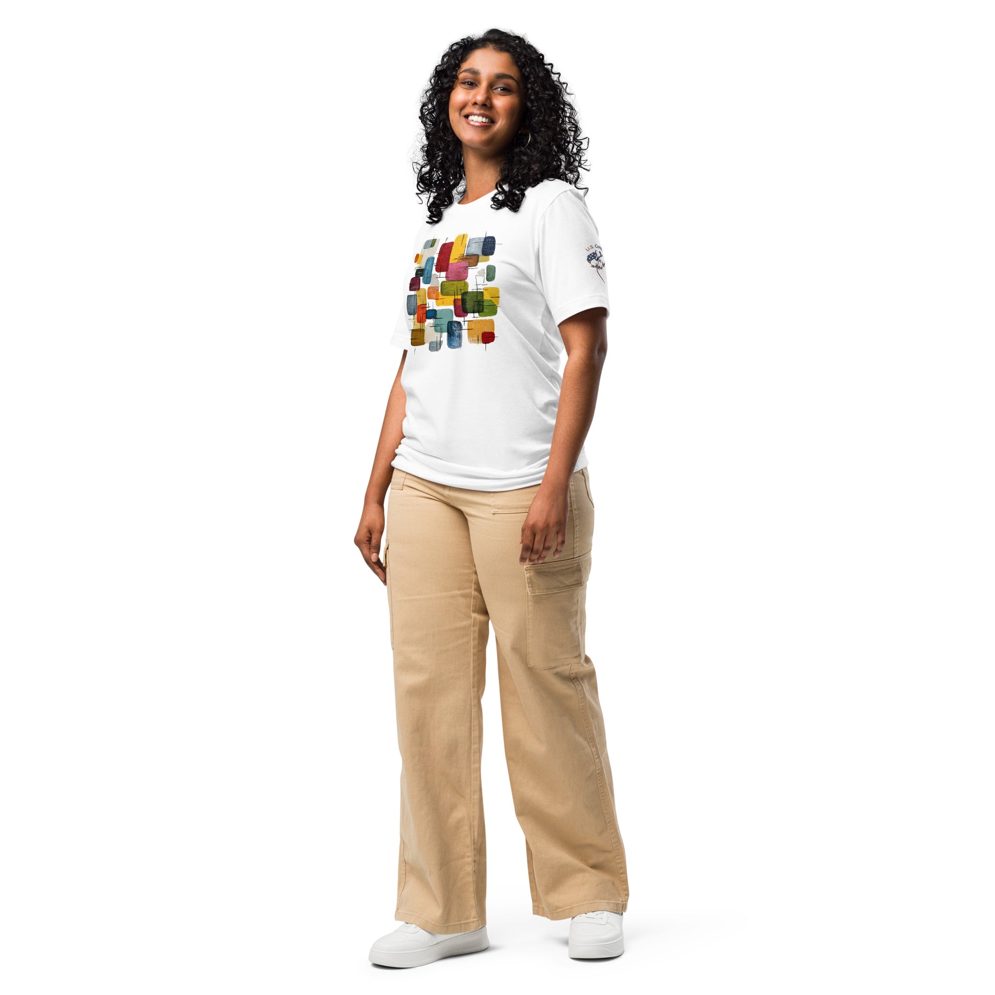 Product mockup. Woman in a white T-shirt featuring colorful, abstract rectangles and "U.S. Cotton" boll emblem on right sleeve, shown full body.