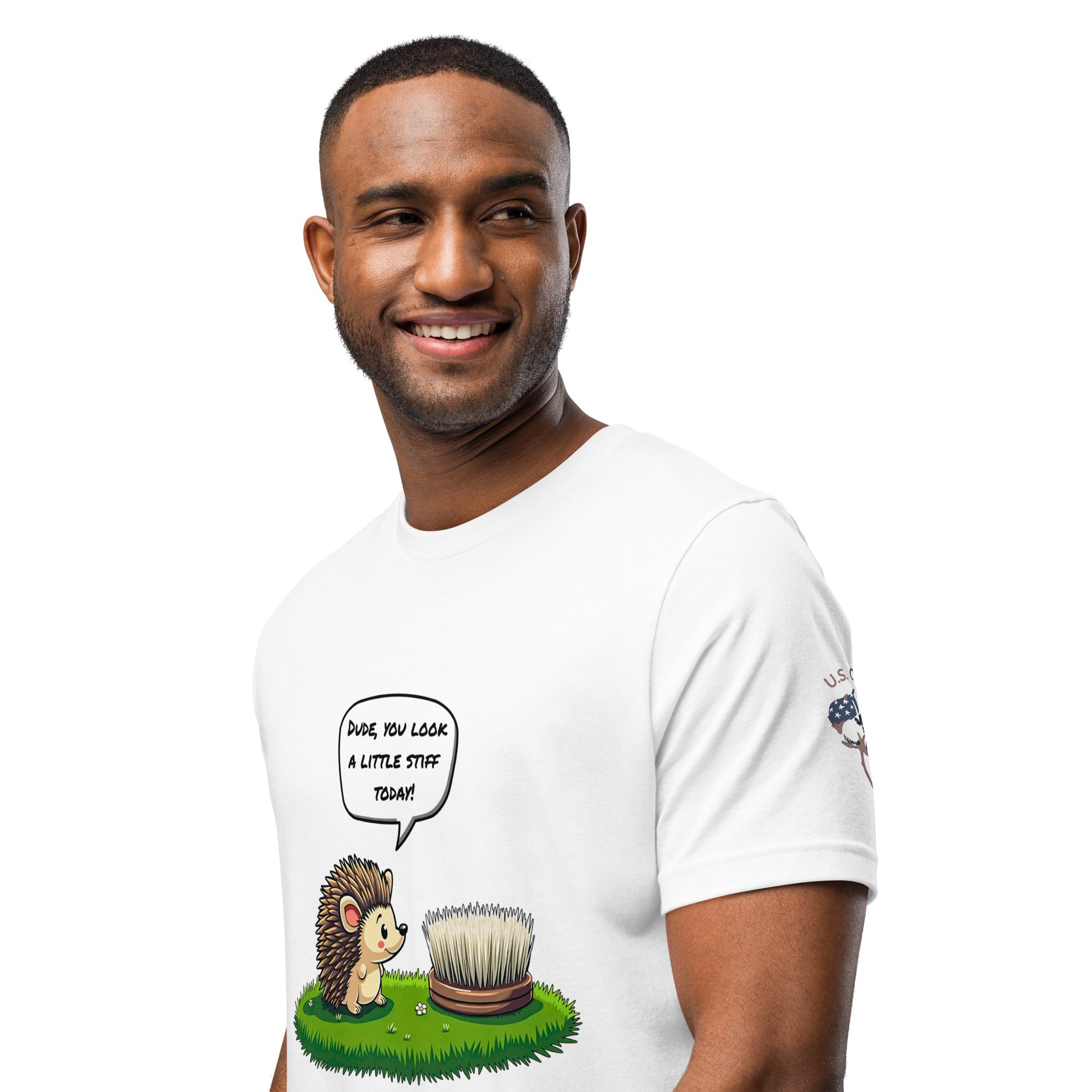 Product mockup. A man wearing a white T-shirt with a cartoon hedgehog saying “Dude, you look a little stiff today!” to a brush resembling a hedgehog, shown from the waist up.
