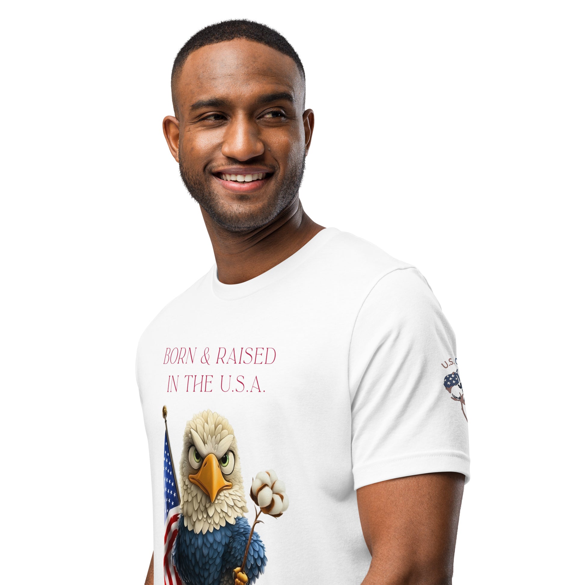Product mockuProduct mockup. Smiling man wearing a white T-shirt with a cartoon bald eagle holding a cotton flower and the American flag, and the text "BORN & RAISED IN THE U.S.A."