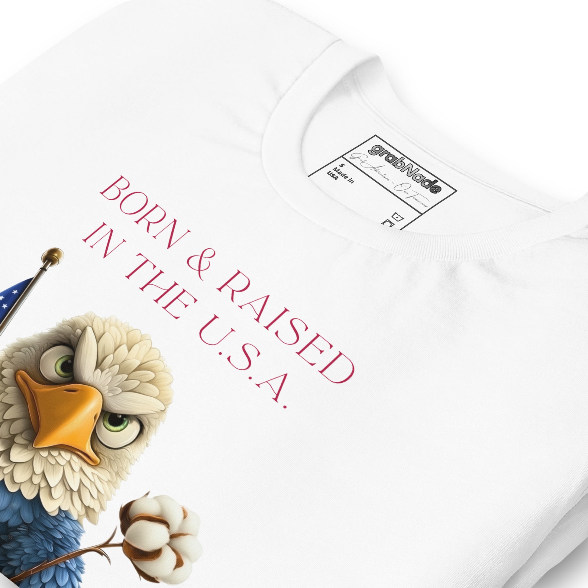 Product mockup. Close-up of a white t-shirt with a cartoon bald eagle holding a cotton boll and the phrase "Born & Raised in the U.S.A."
