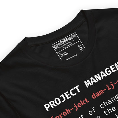 Close up of black t-shirt "Project Management [proh-jekt dam-ij-ment] ctrl+alt+pray" definition.