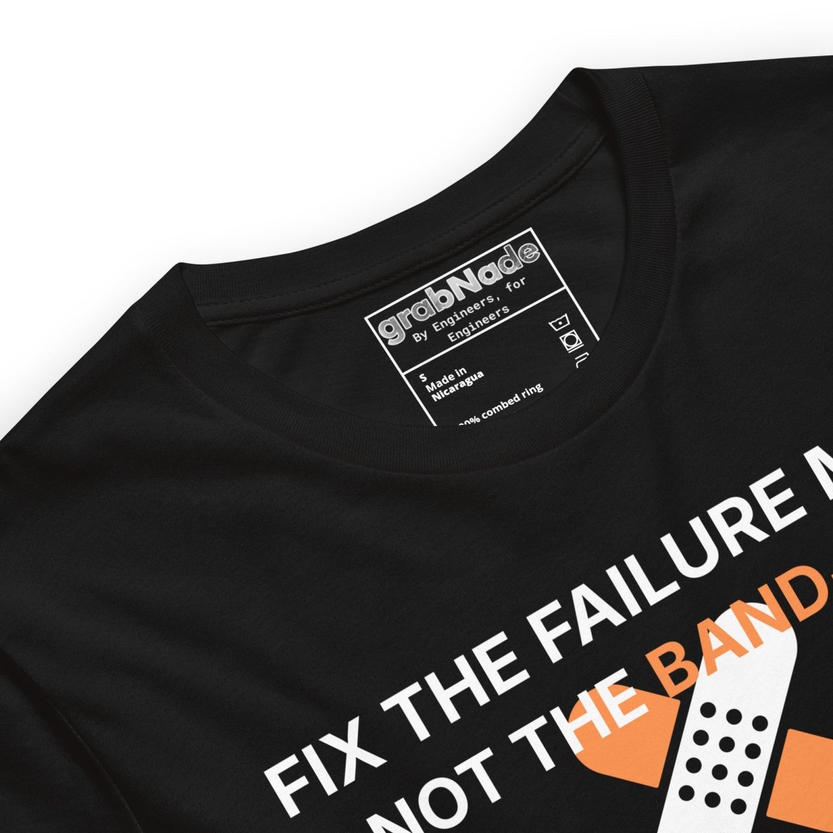 Close up of black t-shirt with "Fix the failure mode. Not the band-aids" text. For engineers & tech.