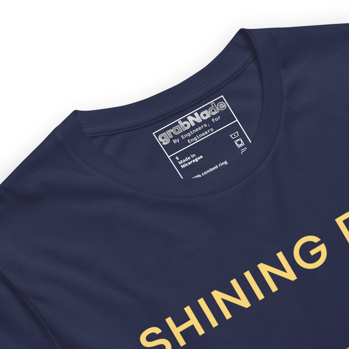Close up of navy tee featuring an Ra0.02 surface finish symbol on a geometric sunset horizon line.