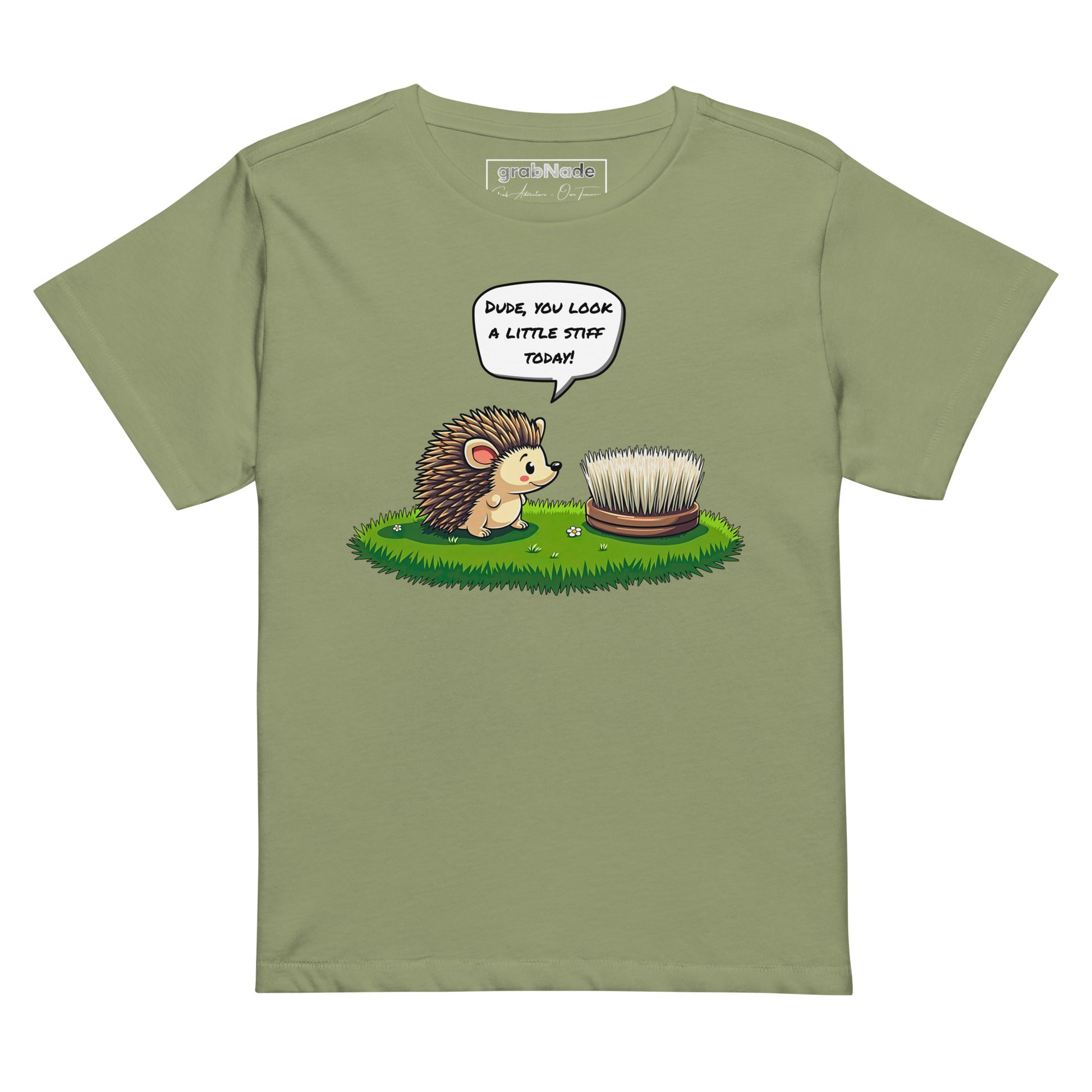 Product mockup. Light green high-waisted women's t-shirt laid flat against a plain background. A colorful cartoon graphic of a hedgehog with a speech bubble—'Dude, you look a little stiff today!'—faces a scrubbing brush on grass. The shirt label at the collar reads 'grabNade.