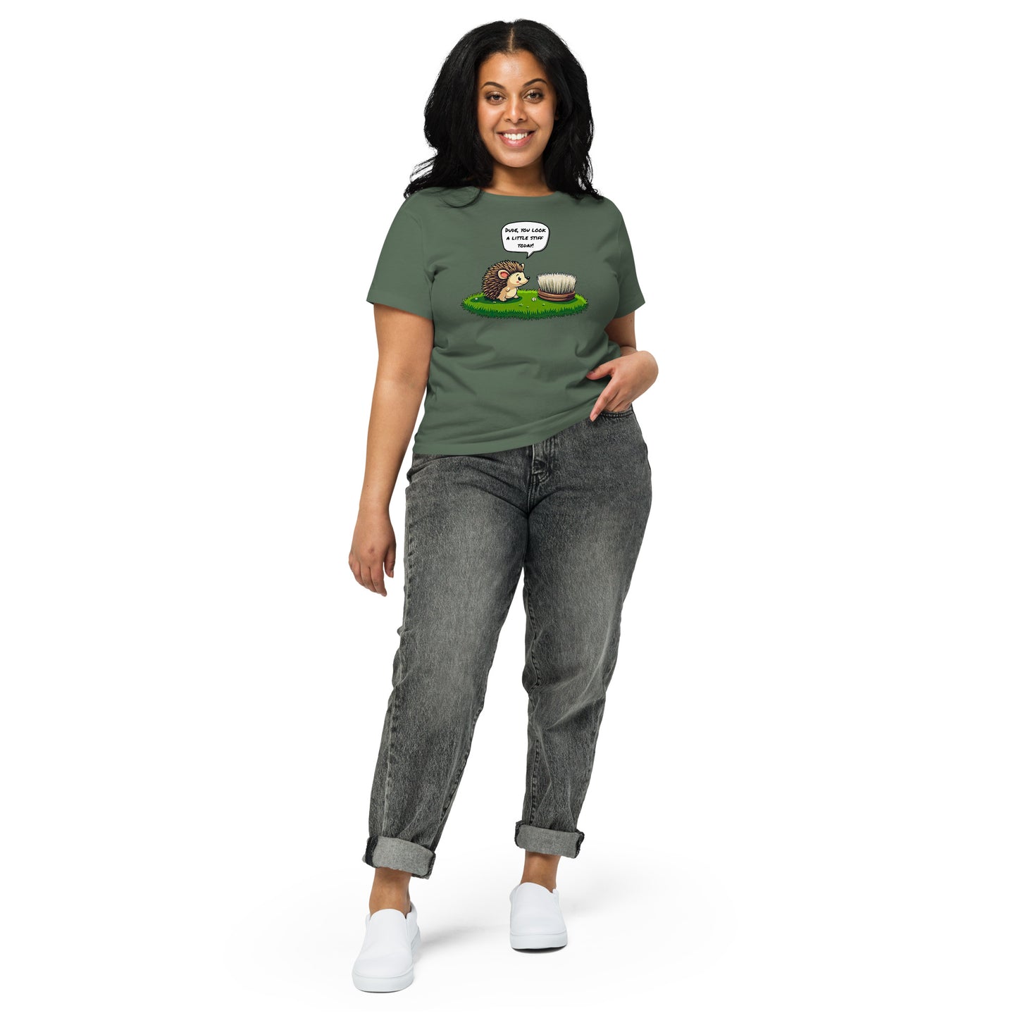 Product mockup. Full-body view of a woman standing and wearing a pine green high-waisted t-shirt with the hedgehog and scrubbing brush cartoon graphic on the front. She is also wearing relaxed-fit gray jeans and white shoes. The setting is a plain white background.