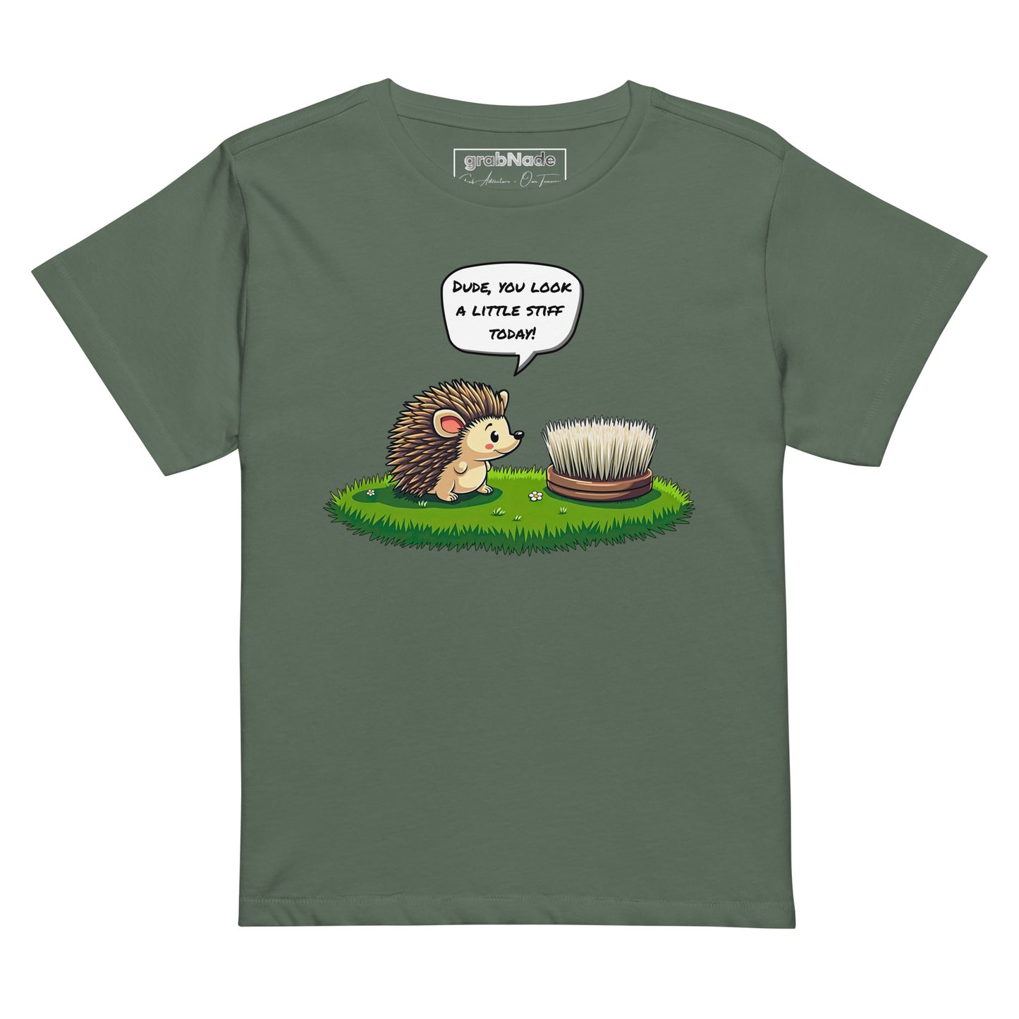 Product mockup. Green pine high-waisted women's t-shirt laid flat against a plain background. A colorful cartoon graphic of a hedgehog with a speech bubble—'Dude, you look a little stiff today!'—faces a scrubbing brush on grass. The shirt label at the collar reads 'grabNade.