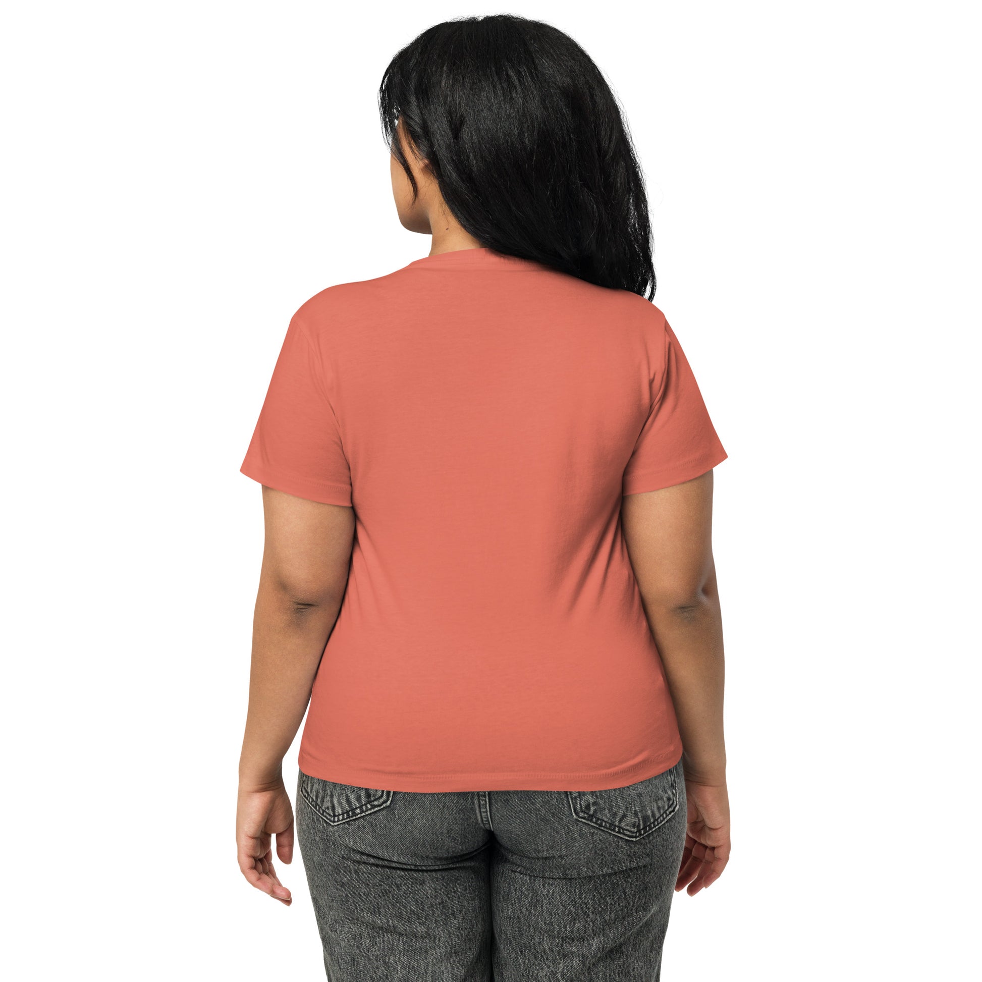 Product mockup. Back view of a woman wearing a red sorbet high-waisted t-shirt and grey pants. The back of the t-shirt is plain, and she is facing away from the camera, standing against a simple white background.