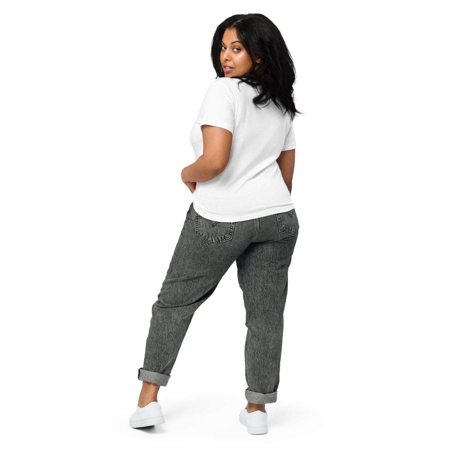 Product mockup. Back view of a woman wearing a white high-waisted t-shirt and light-colored pants. The back of the shirt is plain with no graphics or text, and she is turning her head to look at the camera, set against a clean white backdrop.