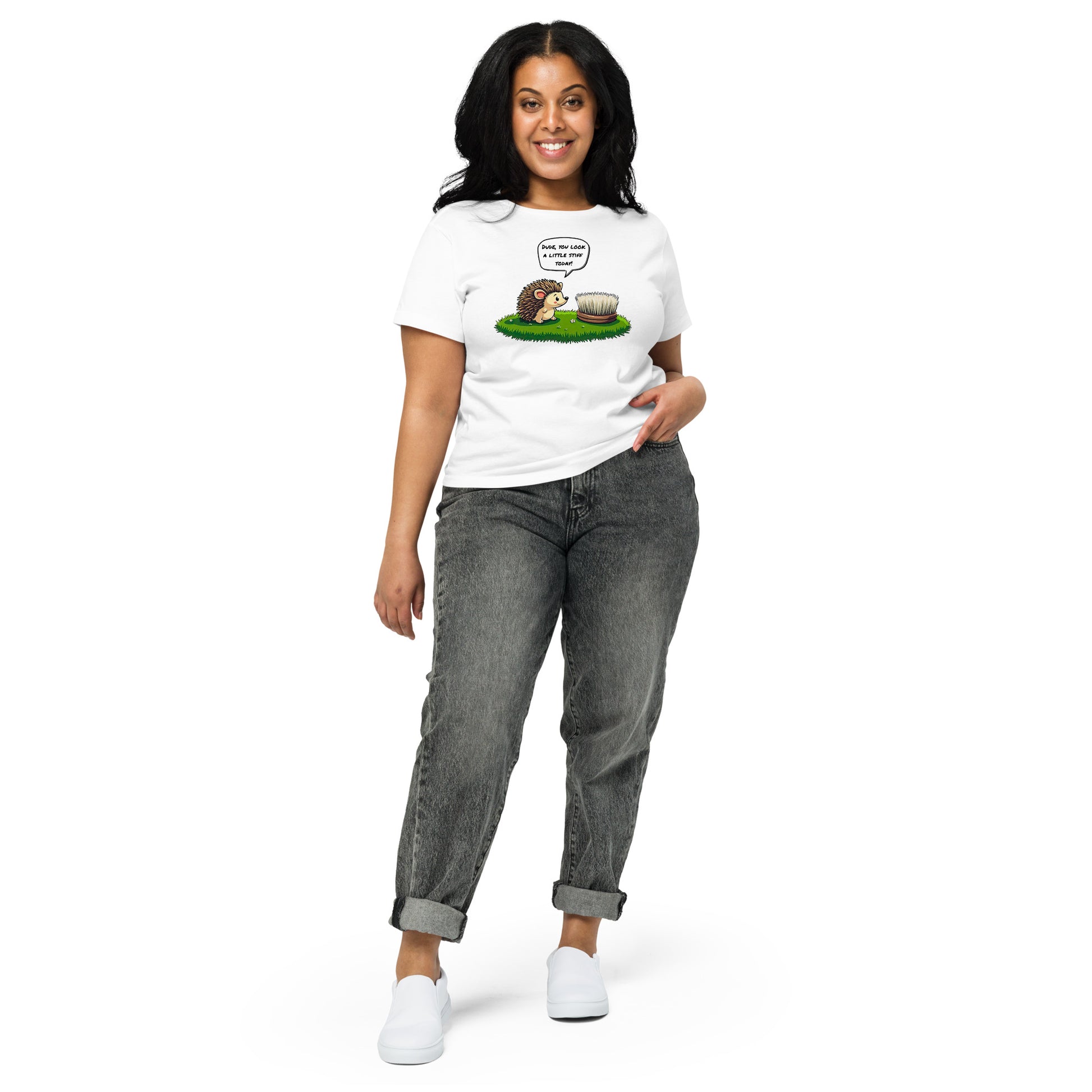 Product mockup. Full-body view of a woman standing and wearing a white high-waisted t-shirt with the hedgehog and scrubbing brush cartoon graphic on the front. She is also wearing relaxed-fit gray jeans and white shoes. The setting is a plain white background.