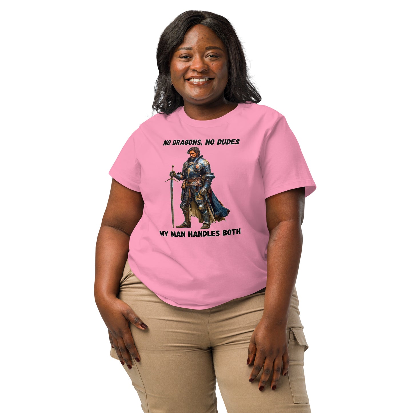 Product mockup. Organic premium pink t-shirt featuring warrior knight in detailed armor holding sword with bold black text above and below stating 'NO DRAGONS, NO DUDES MY MAN HANDLES BOTH,' modeled on smiling woman.
