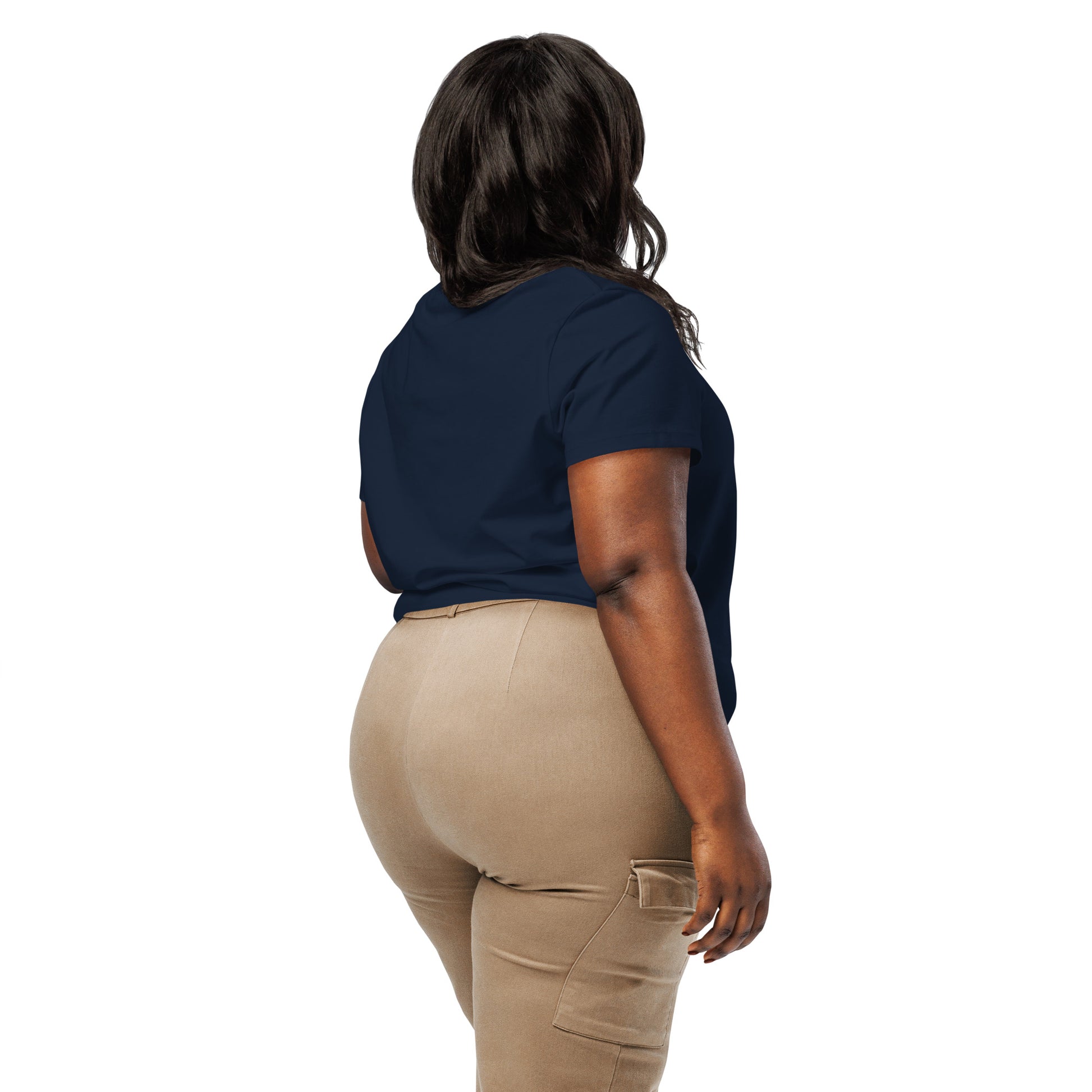 Product mockup. A woman shown from behind wearing a plain navy blue organic cotton t-shirt with short sleeves. The shirt has a relaxed fit, and no design or graphics appear on the back. She is also wearing khaki pants with side pockets.