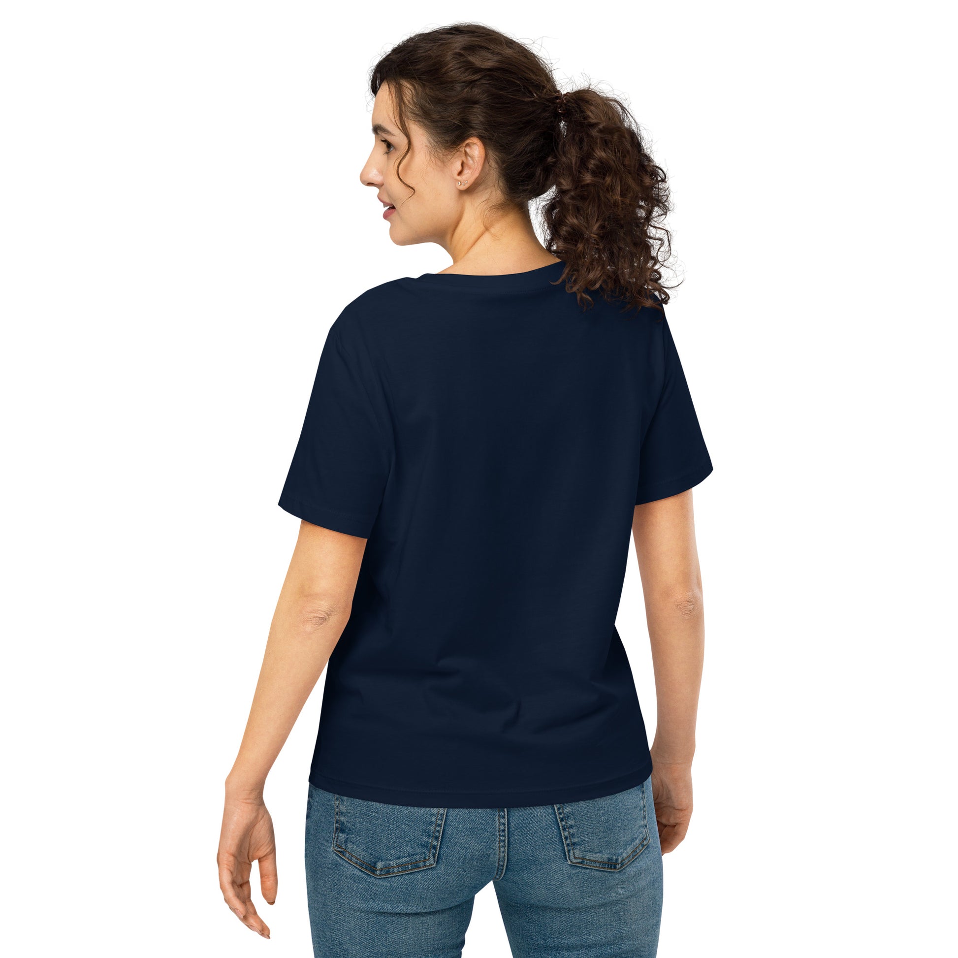 Product mockup. A woman shown from behind wearing a plain navy blue organic cotton t-shirt with short sleeves. The shirt has a relaxed fit, and no design or graphics appear on the back. She is also wearing blue jeans pants.