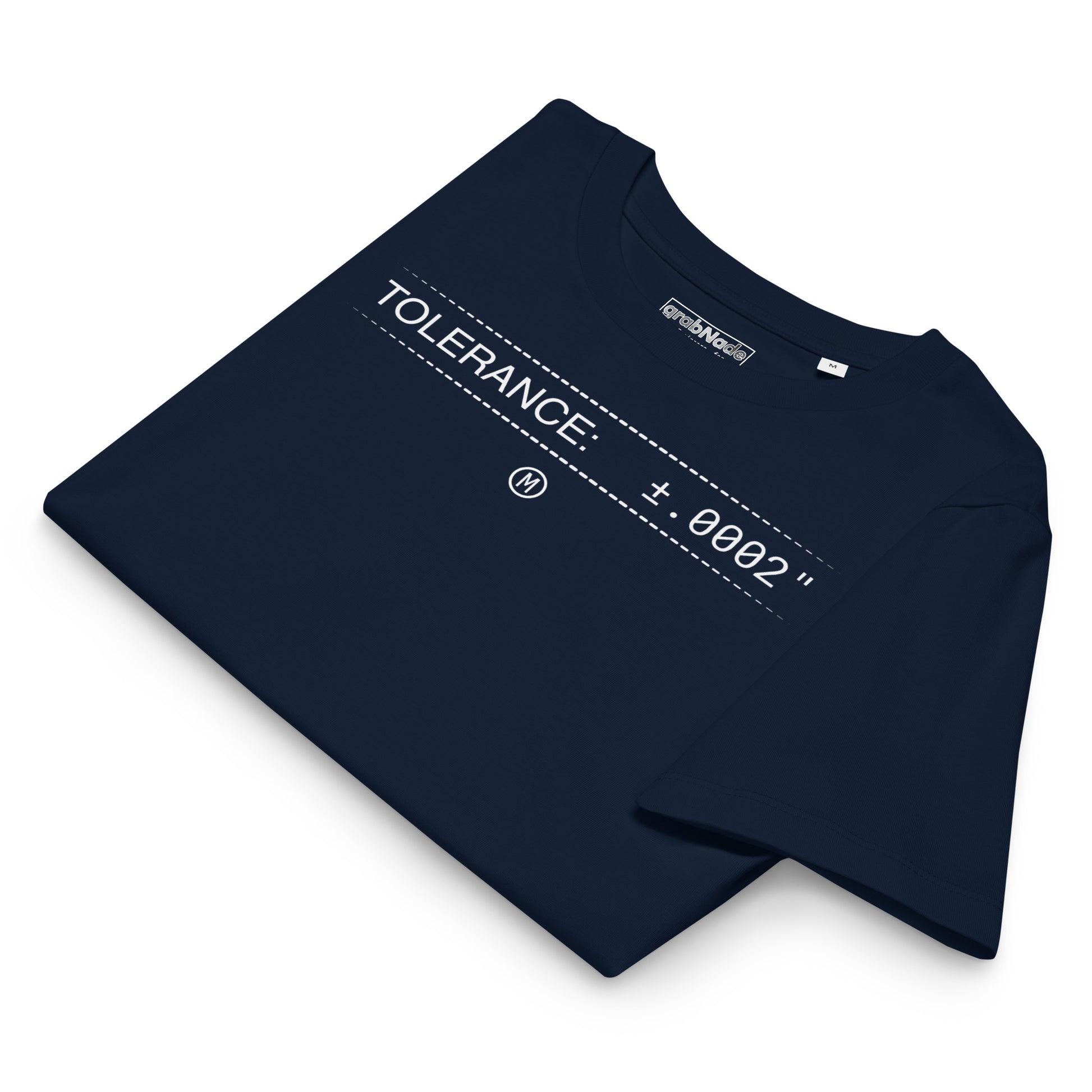 Folded organic navy premium t-shirt with white text "TOLERANCE: ±.0002" for mechanical engineers.
