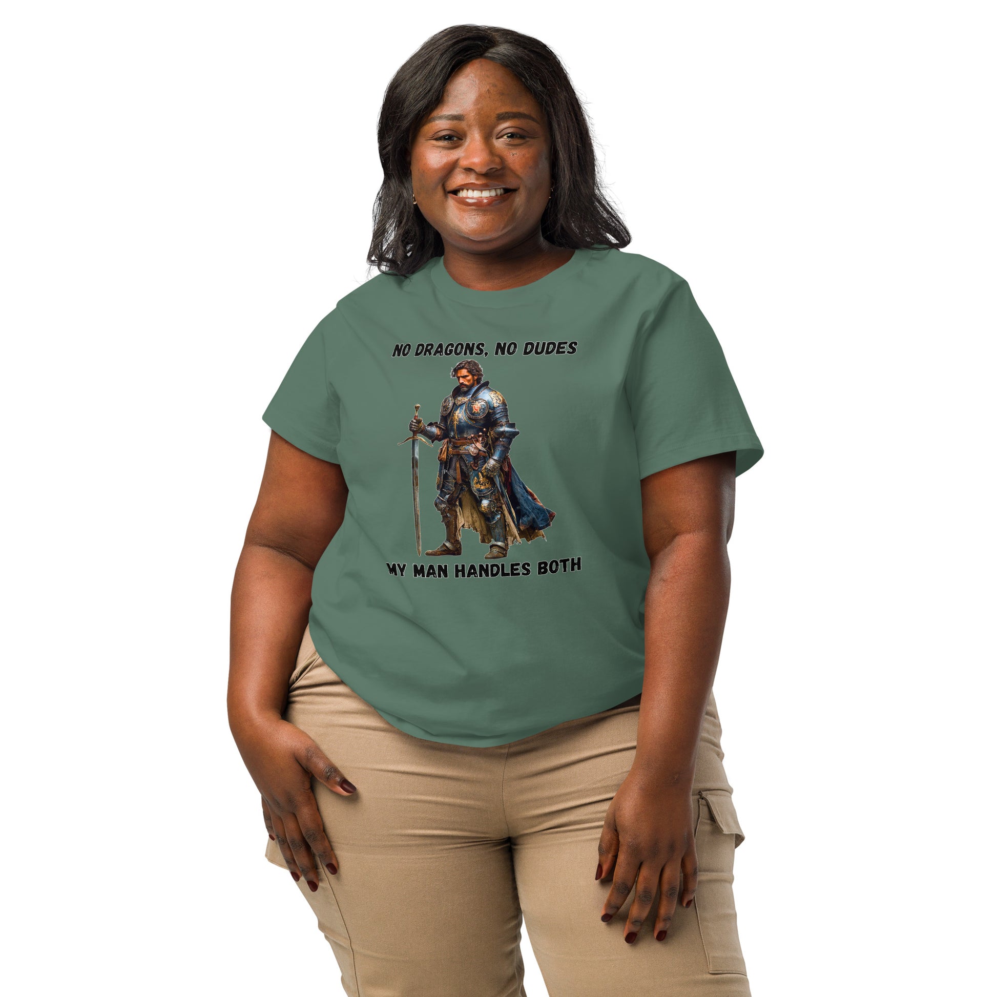 Product mockup. Organic premium green t-shirt featuring warrior knight in detailed armor holding sword with bold black text above and below stating 'NO DRAGONS, NO DUDES MY MAN HANDLES BOTH,' modeled on smiling woman.