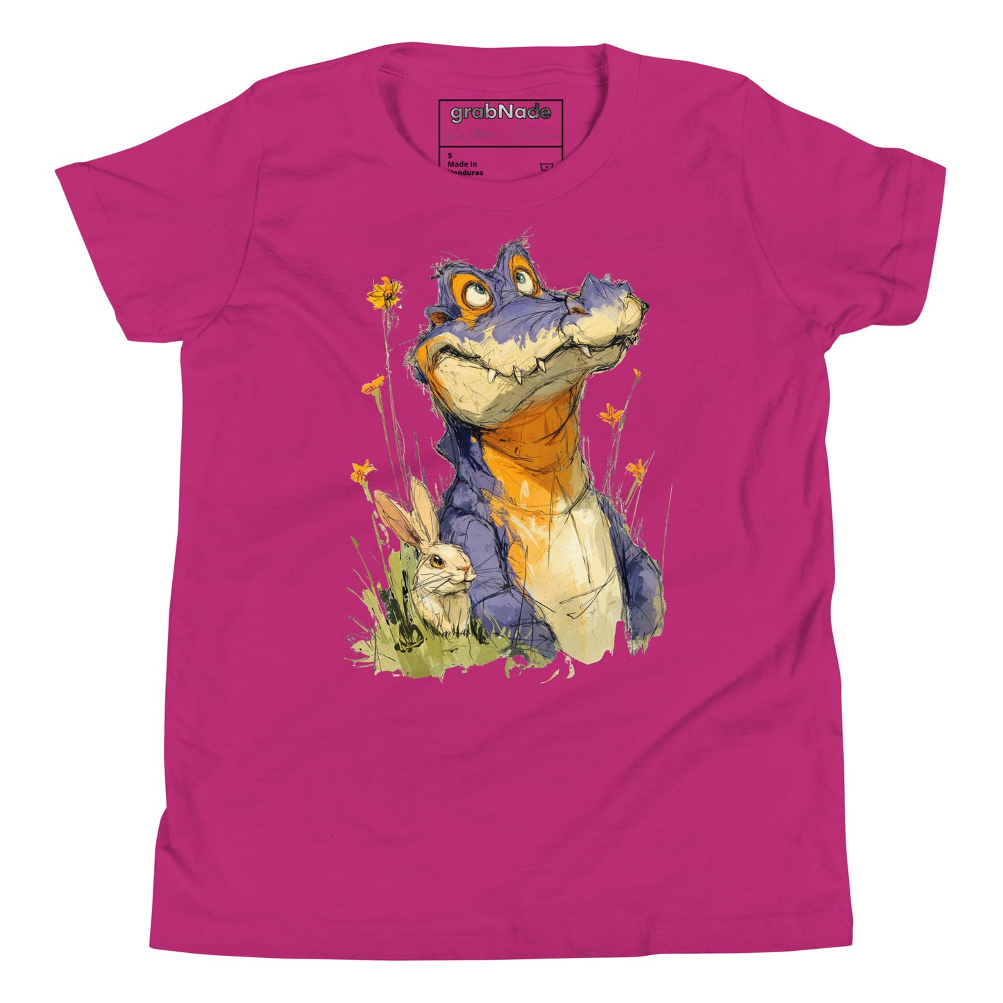 Product mockup. A playful, sketch-style illustration of a cheerful purple alligator with bright orange accents sitting in tall grass and wildflowers, accompanied by a white rabbit nestled by its side. Both characters feature expressive faces and are set against a plain pink t-shirt background, creating a whimsical and friendly scene.